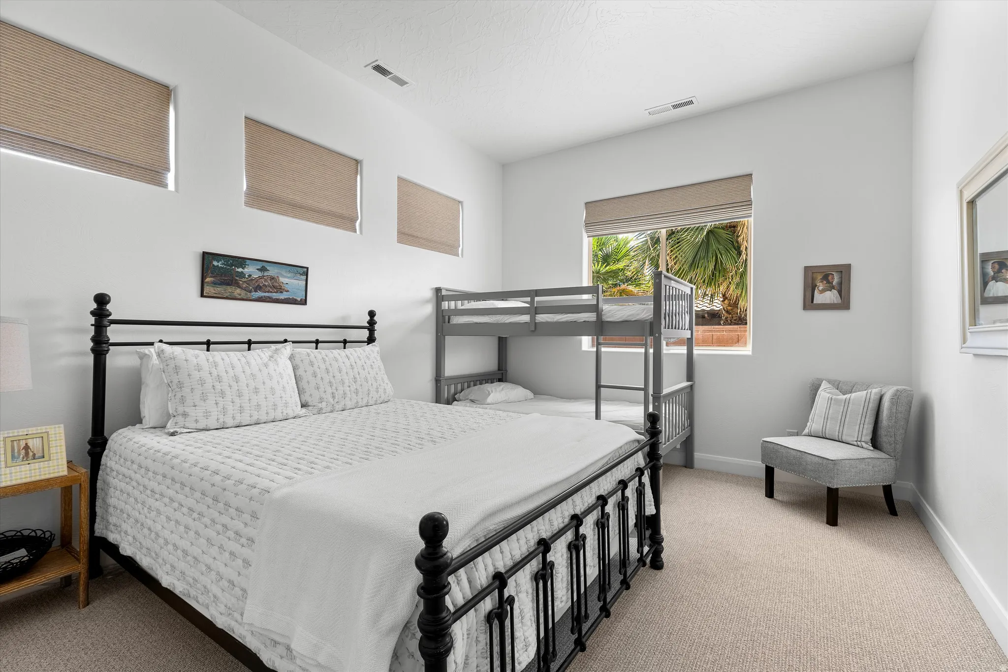 Bright bedroom featuring light-toned carpeting and white walls