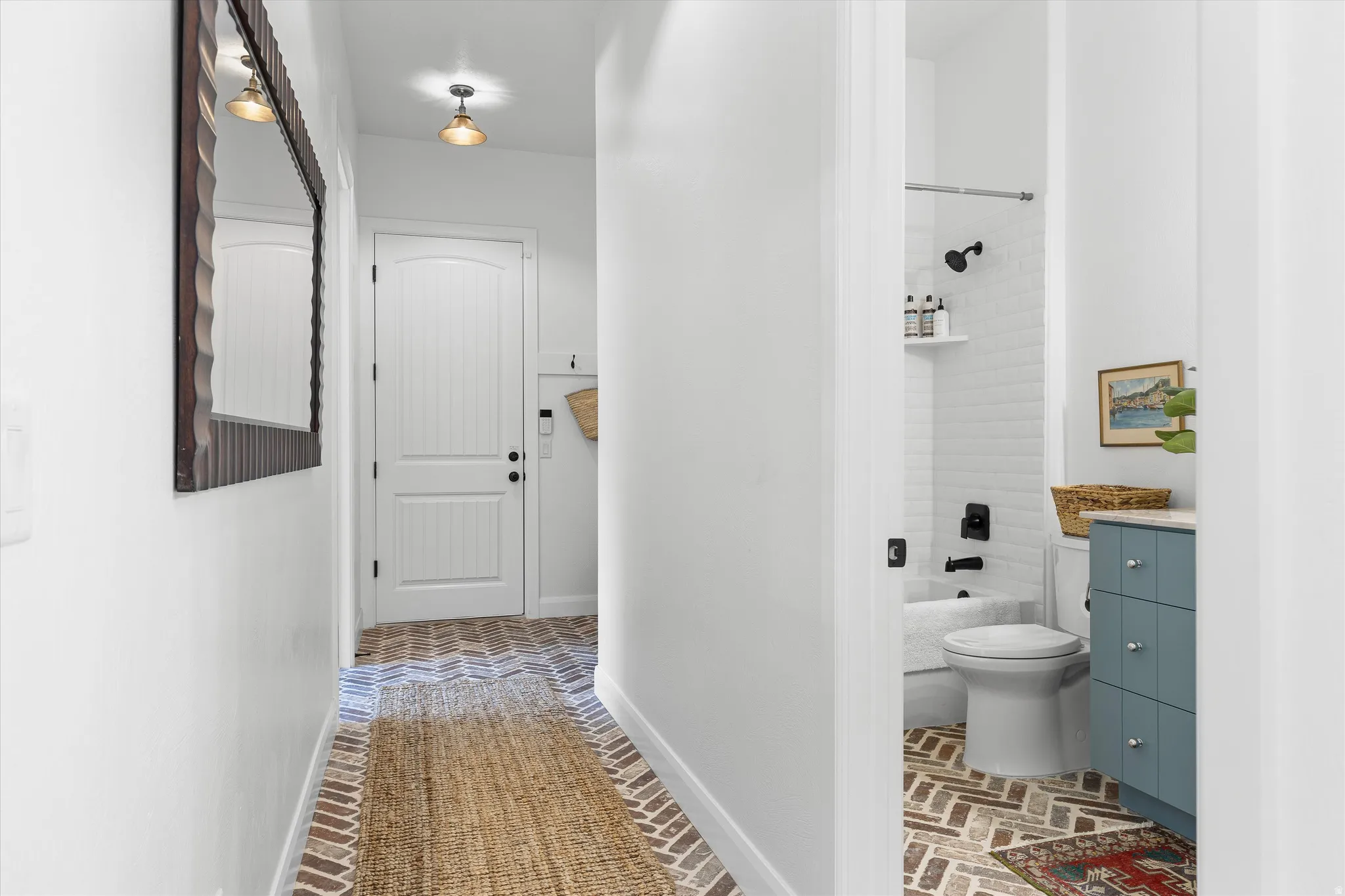 Herringbone pattern brick flooring throughout the hallway and bathroom