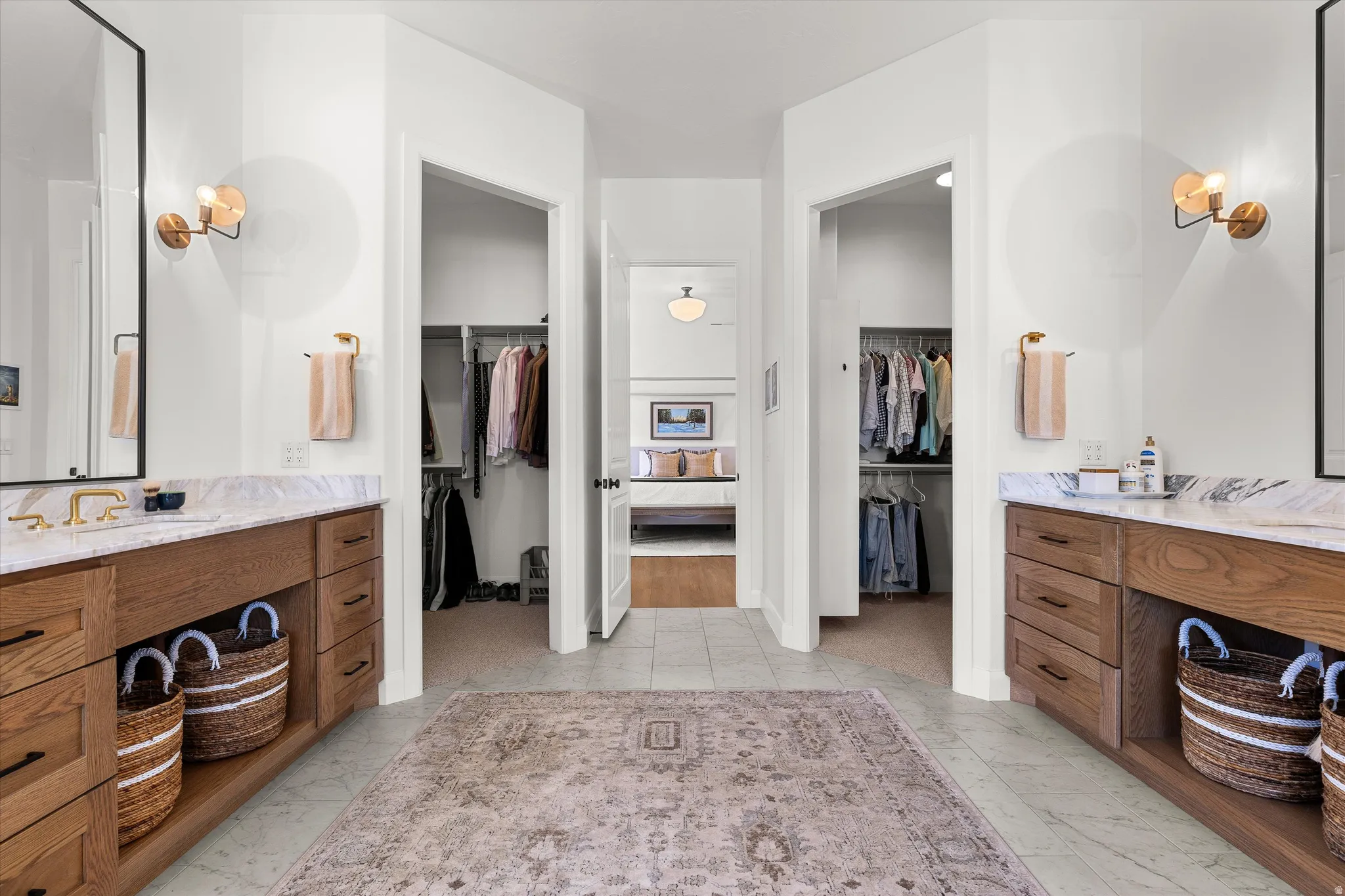 Dual custom wood vanities with undermount sinks and stone countertops