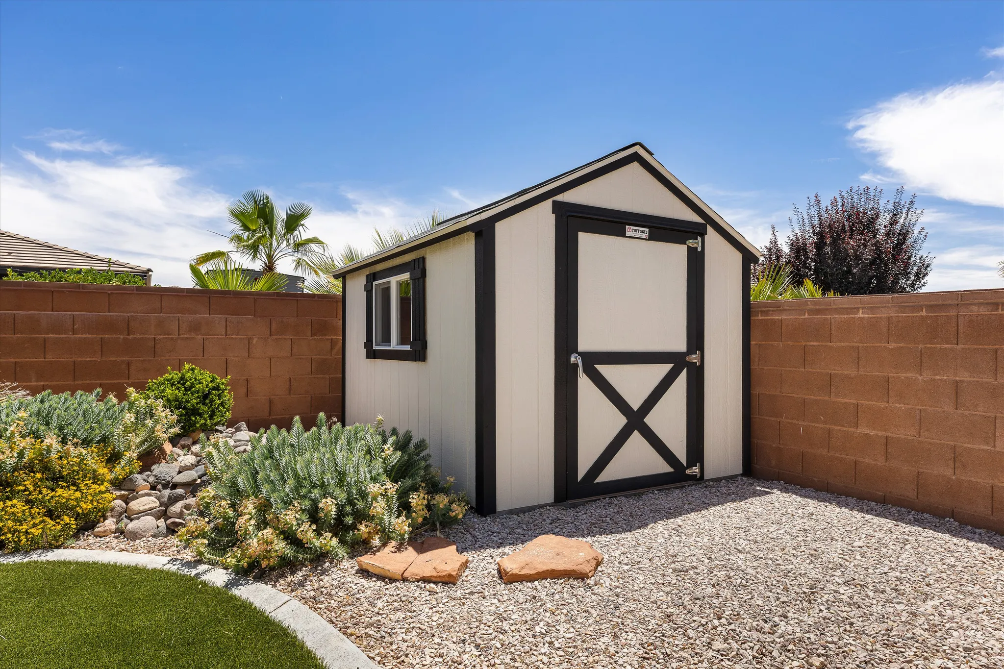 Detached storage shed featuring a gabled roof and a side window