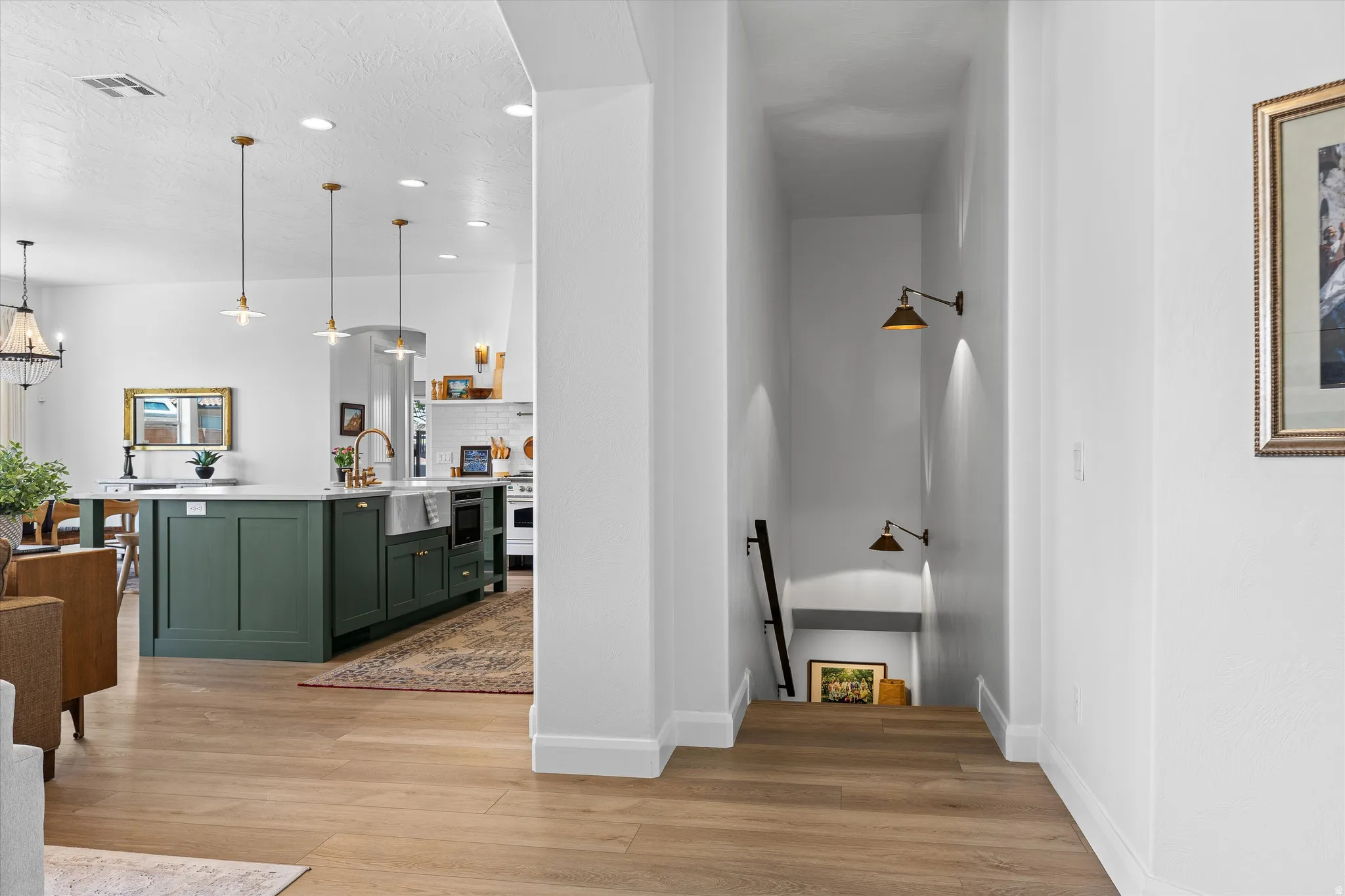 Kitchen island with a farmhouse sink, gold-finish faucet, and pendant lighting