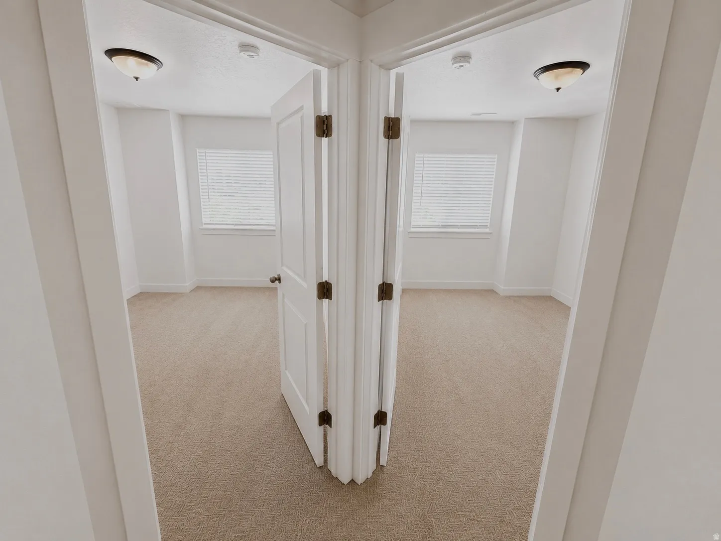 Two separate rooms featuring light-colored carpet flooring, white walls, and white trim