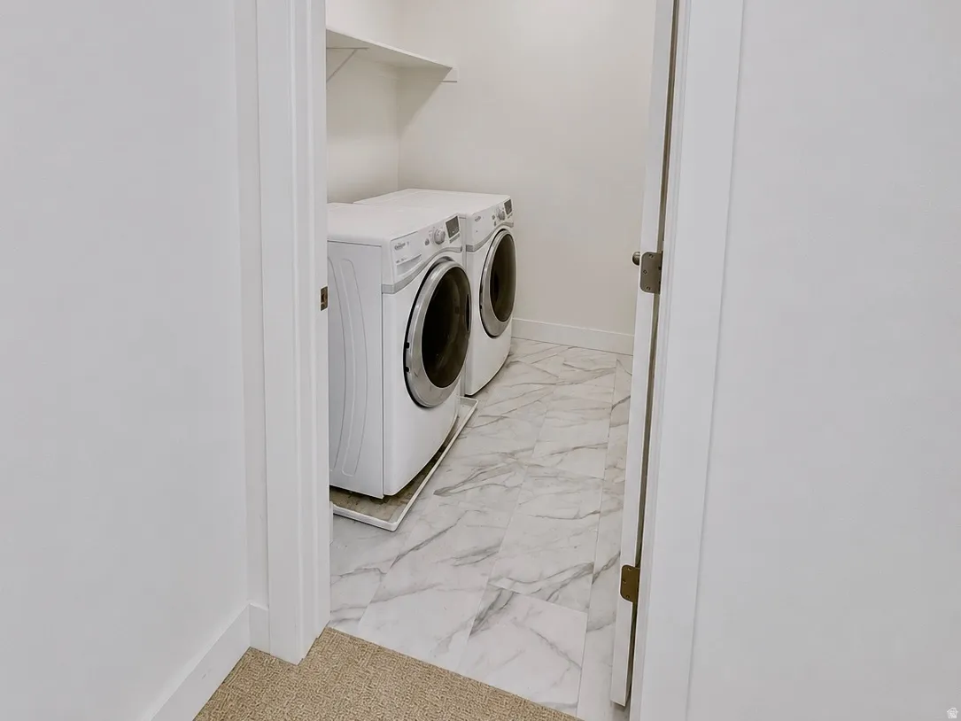 Utility space featuring white walls, durable flooring, and an elevated shelf