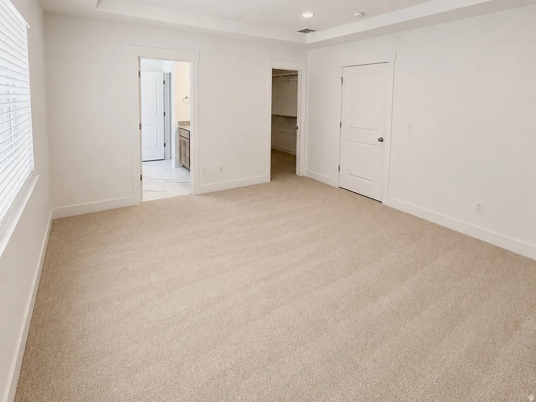 Carpeted interior space featuring white walls and trim