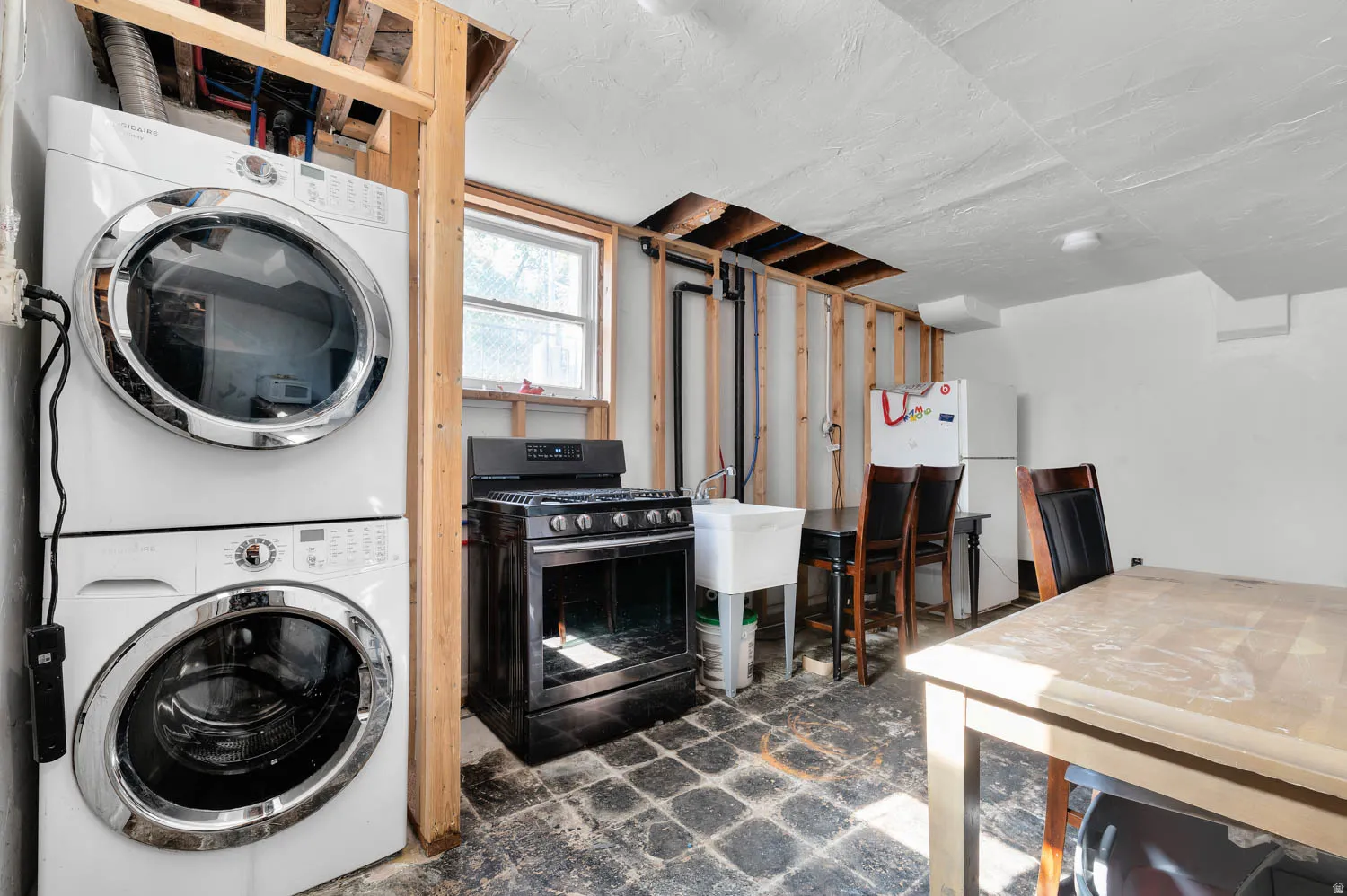 Dedicated laundry area featuring a stacked washer and dryer unit