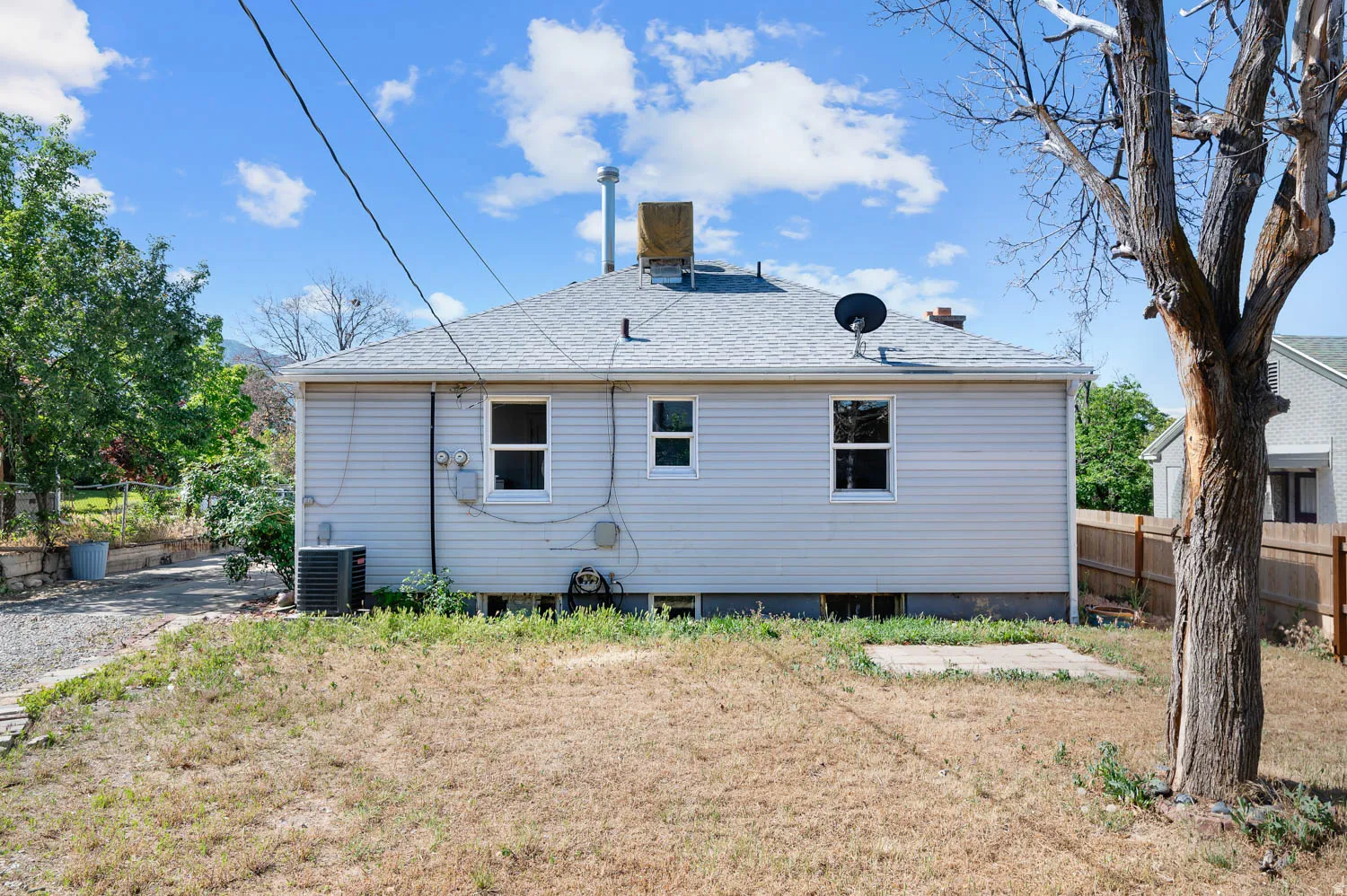 Rear exterior of the property featuring horizontal siding and a gray asphalt shingle roof