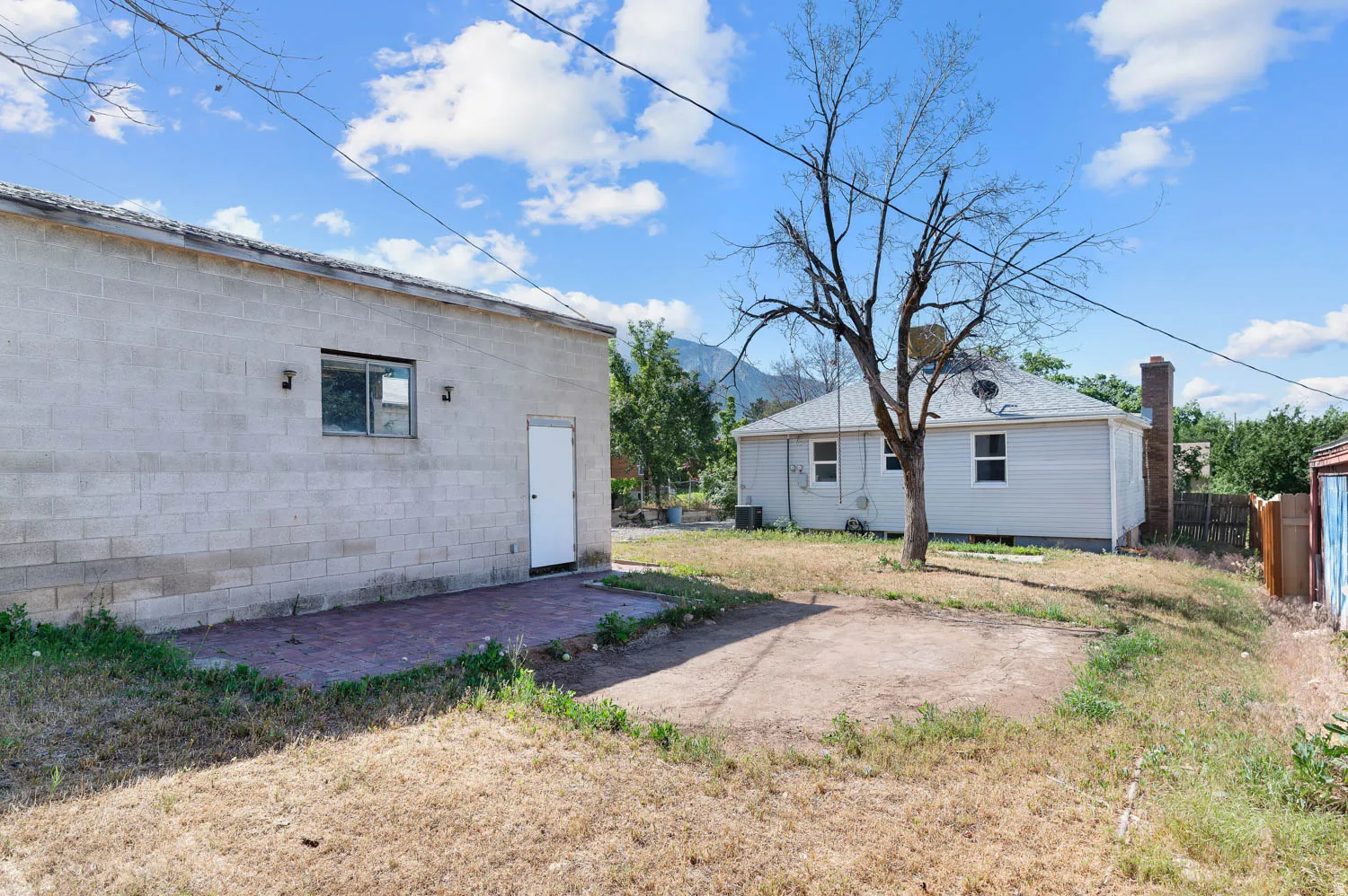 Block construction auxiliary building featuring a window, exterior lighting fixtures, and a white entry door