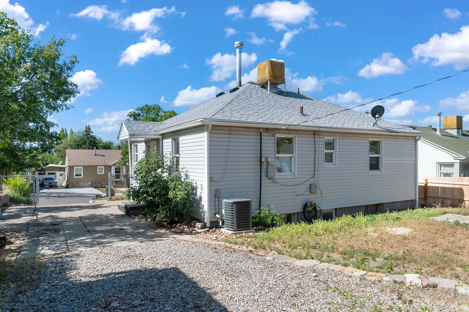 Rear exterior featuring light-colored siding and a gray shingle roof