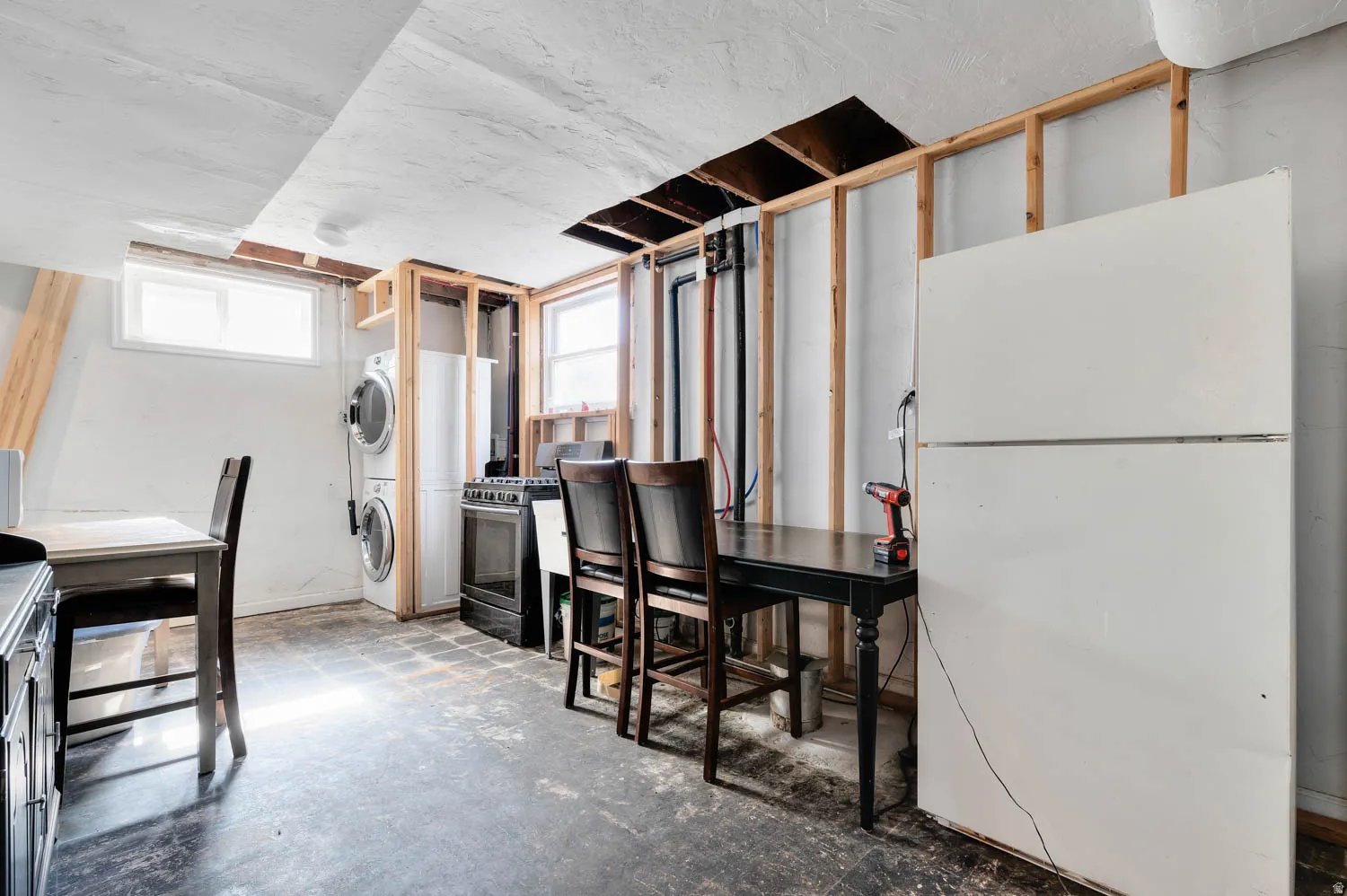 Basement utility area featuring exposed wall framing, concrete flooring, and an existing window