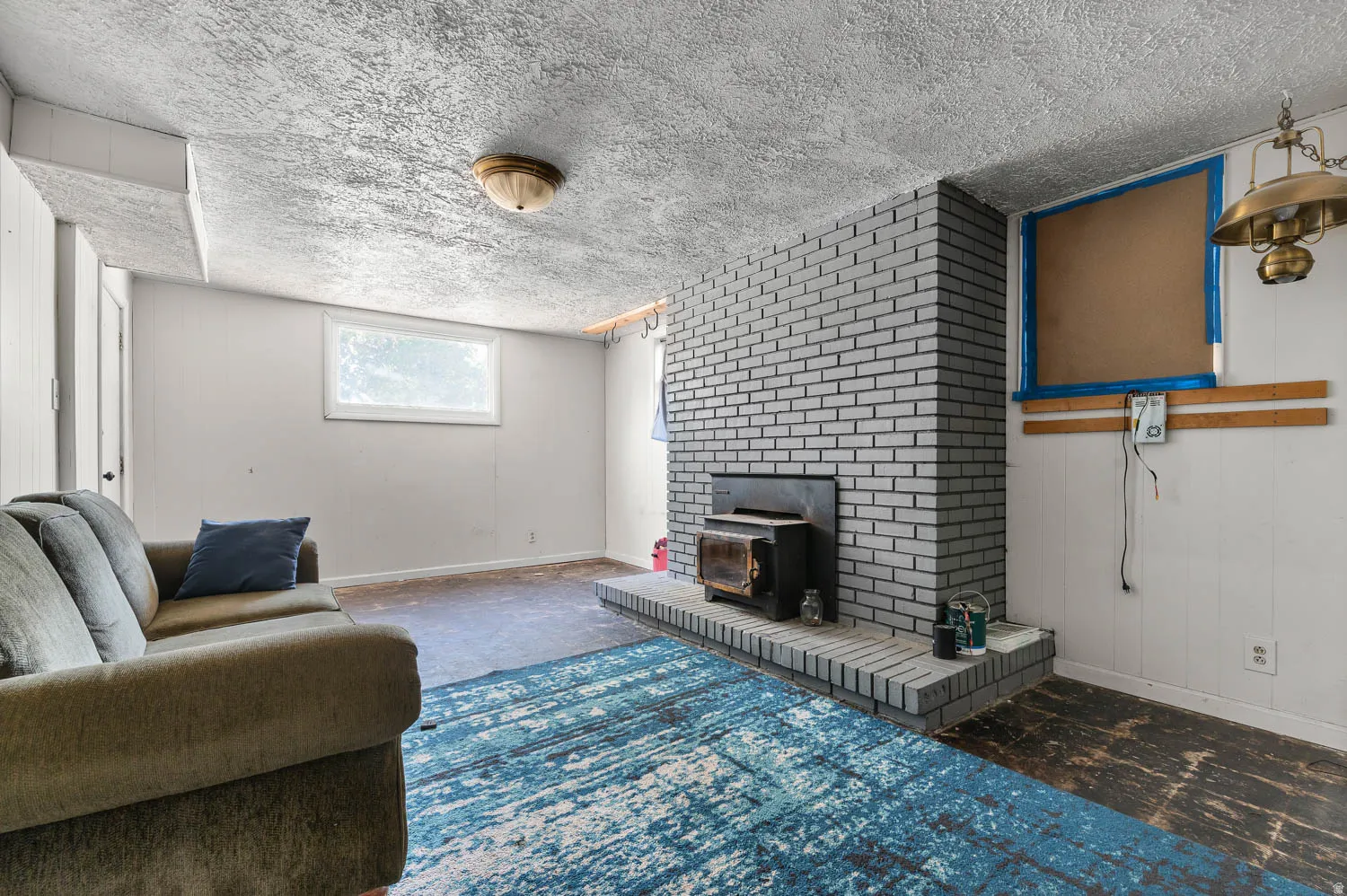 Expansive room featuring a painted brick fireplace with a wood-burning insert