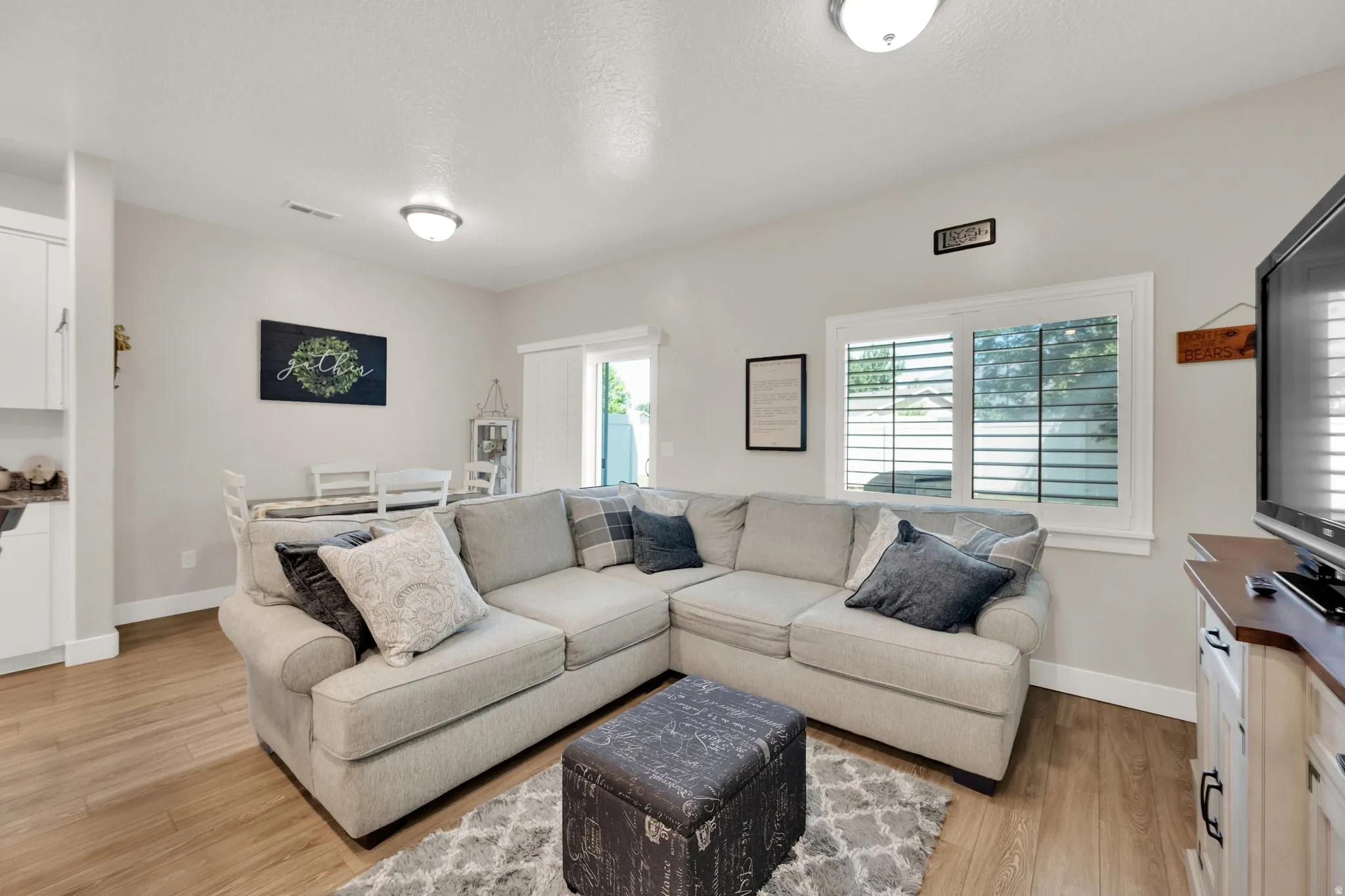Open-concept living area with wood-finish flooring, recessed lighting, and a dining space
