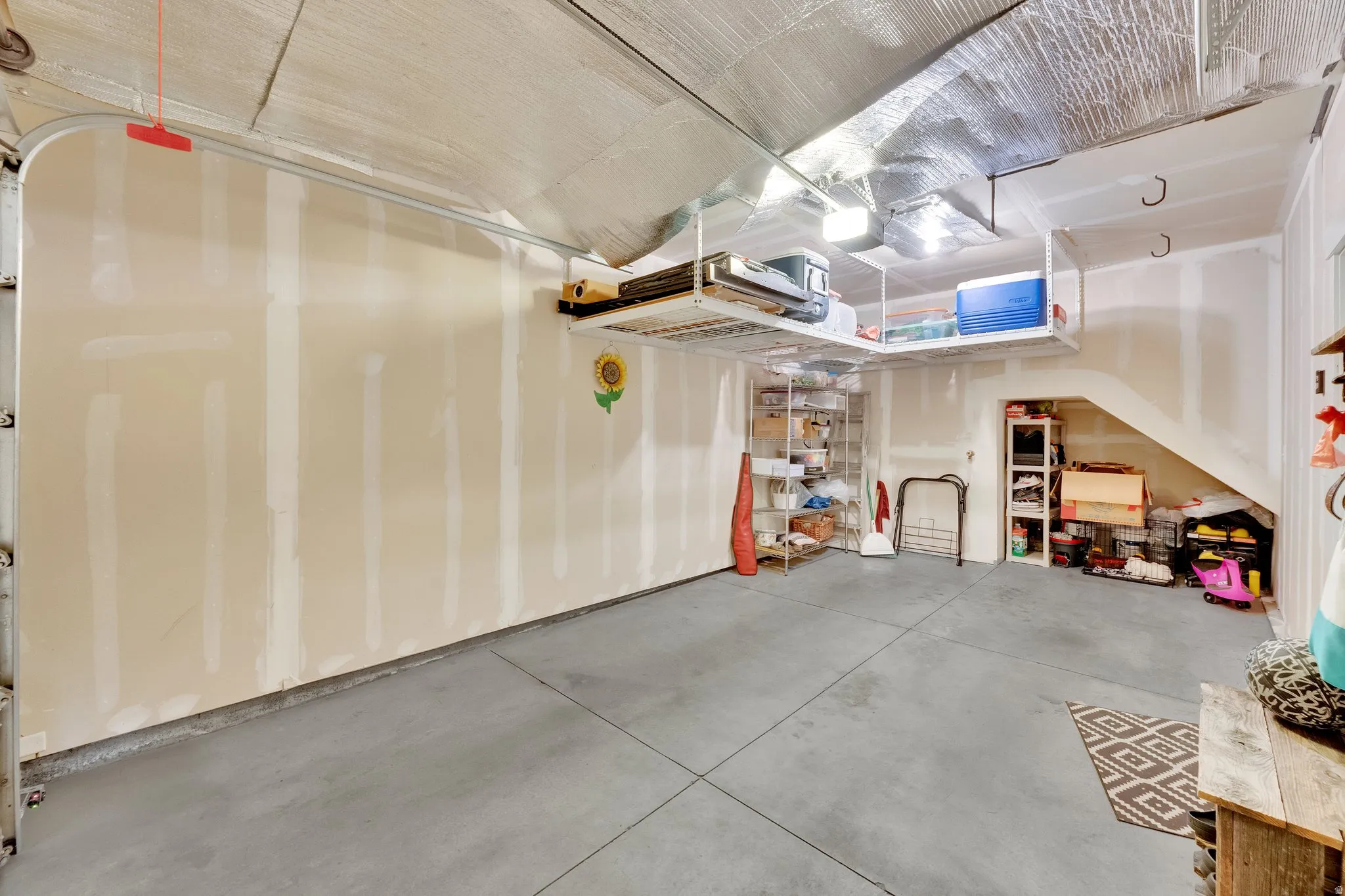 Spacious garage featuring concrete flooring and exposed drywall