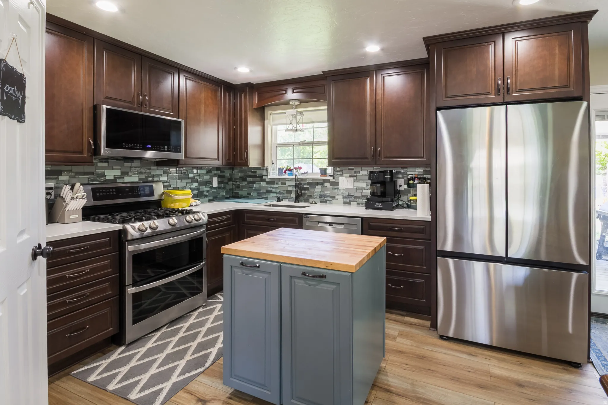 Well-appointed kitchen featuring wood-finish flooring and rich brown cabinetry