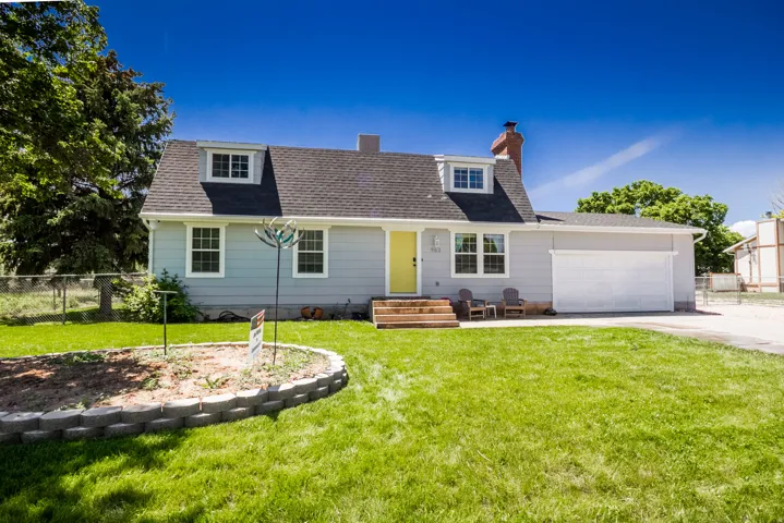 Light gray siding residence featuring a dark shingle roof with dormer windows
