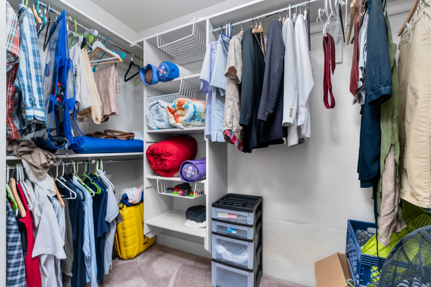 Custom closet system featuring multiple hanging rods, white shelving, and integrated wire baskets