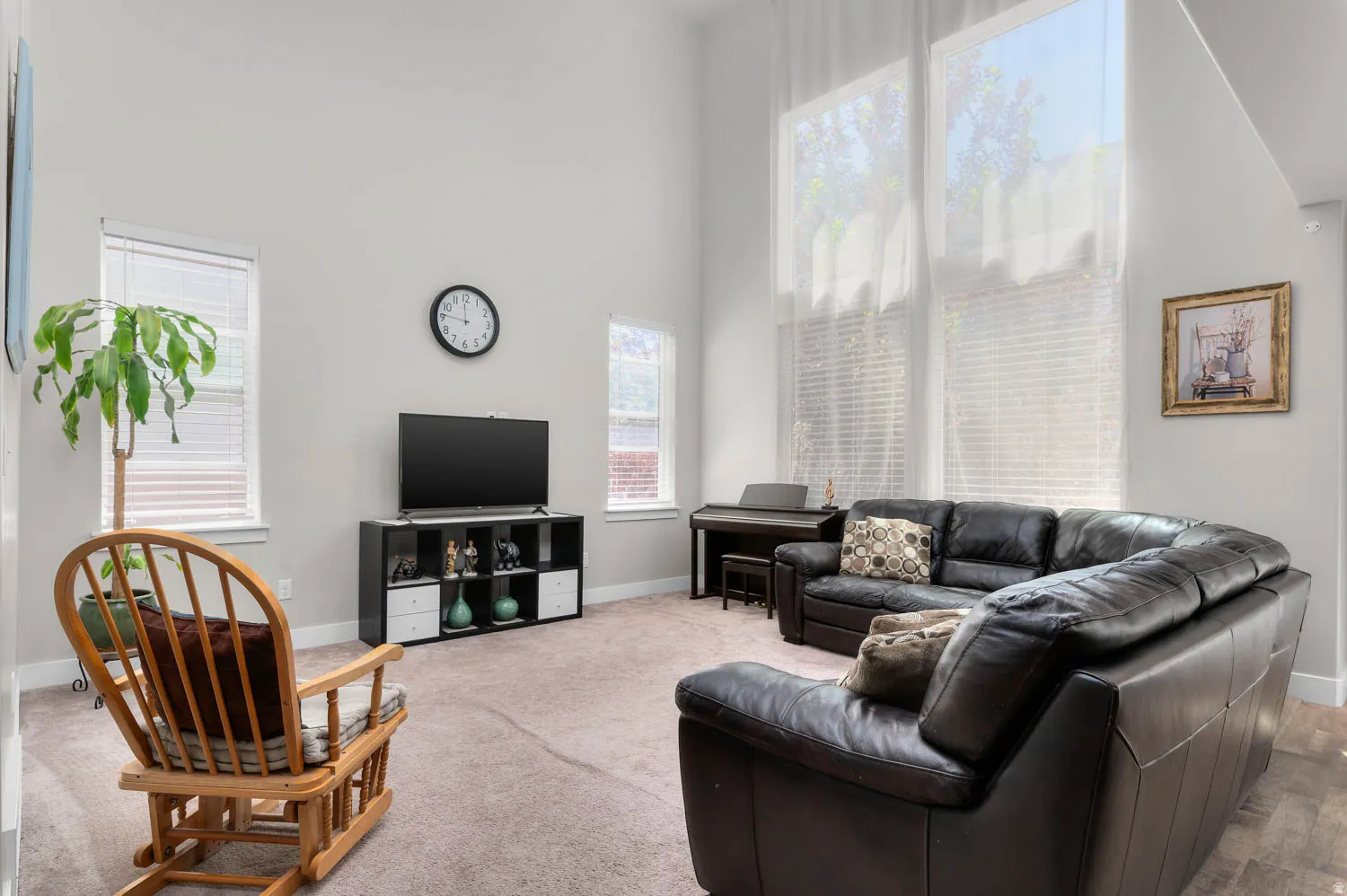 Living area with vaulted ceilings and large windows featuring window treatments