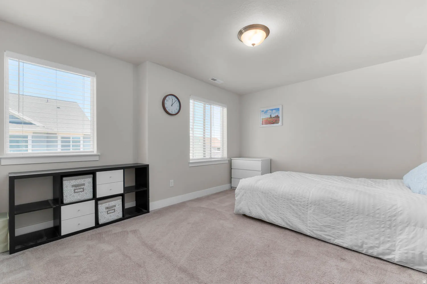 Carpeted room featuring dual windows with blinds, light gray wall paint, and a semi-flush mount ceiling light