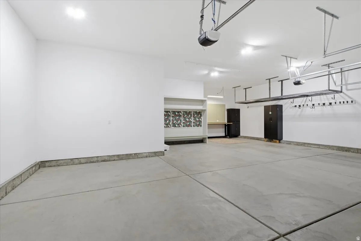 Spacious garage with light grey concrete flooring and white walls