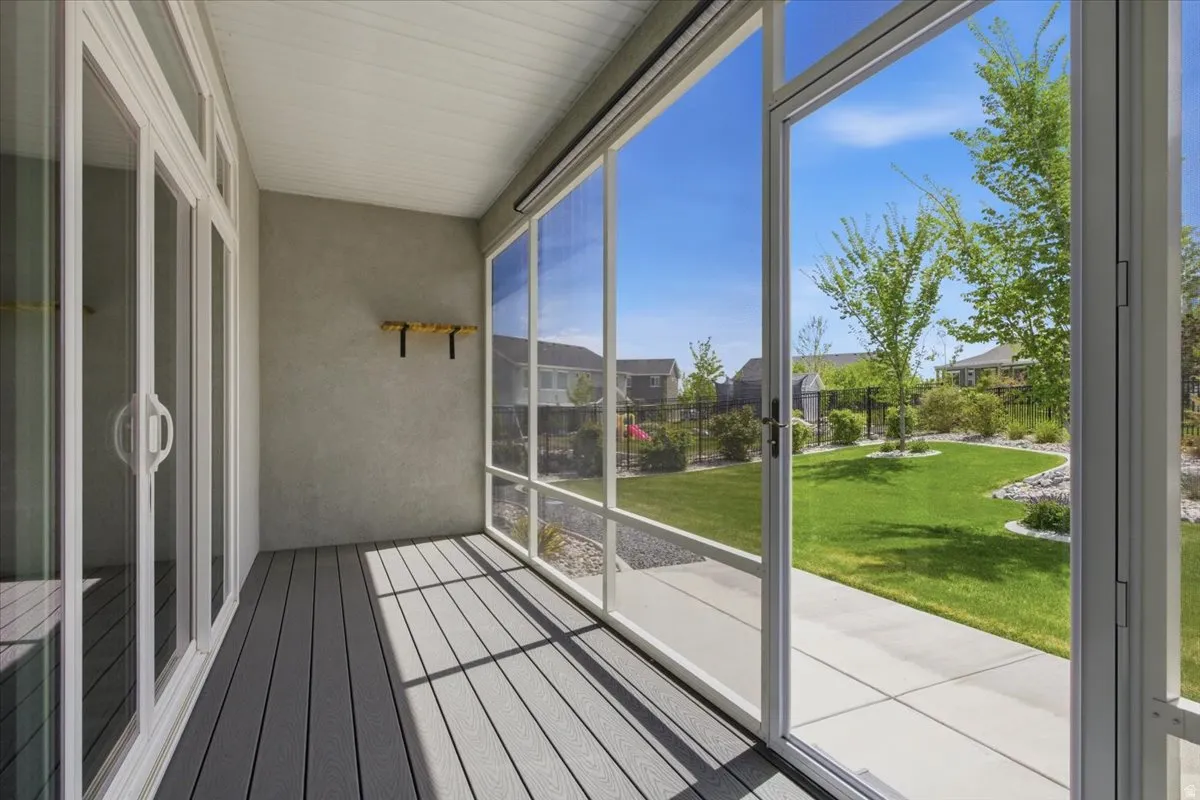 Screened porch featuring gray wood-finish decking, white slatted ceiling, and expansive windows