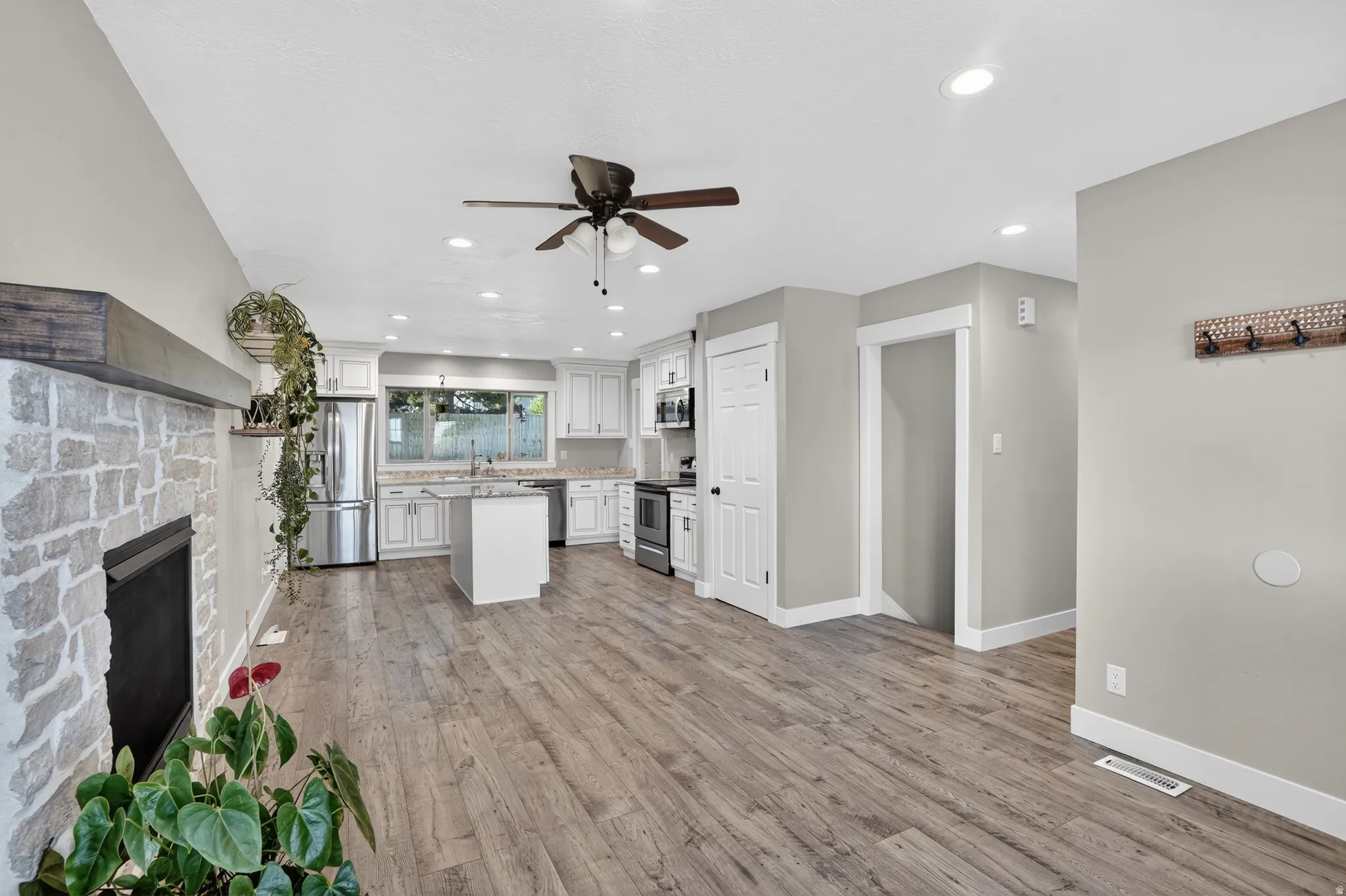 Open-concept living area featuring wood-finish flooring, recessed lighting, and a ceiling fan