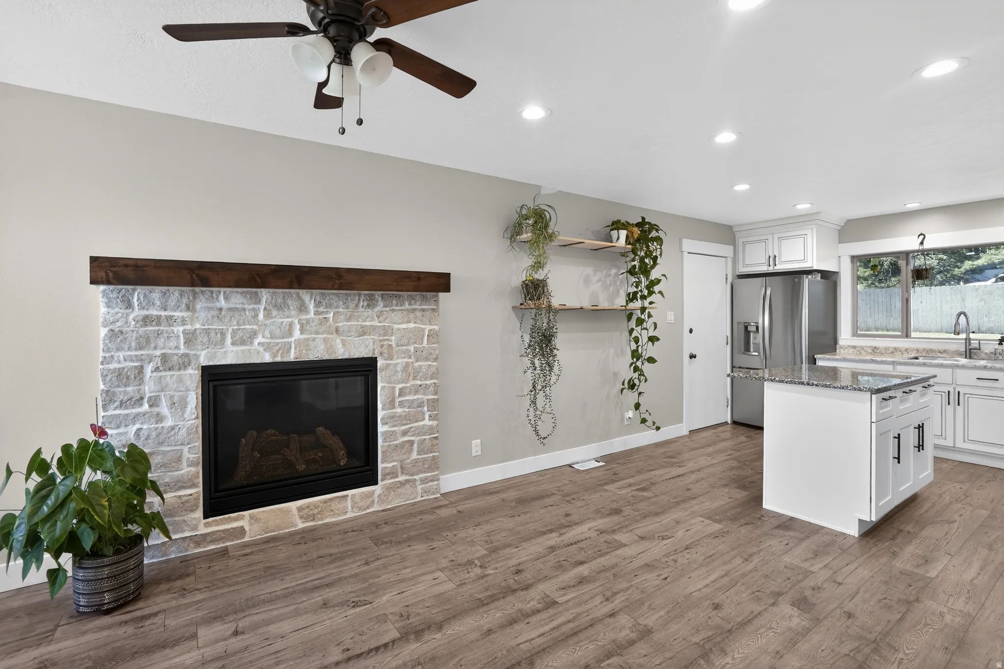 Living area featuring a stone-faced fireplace with a wood mantel