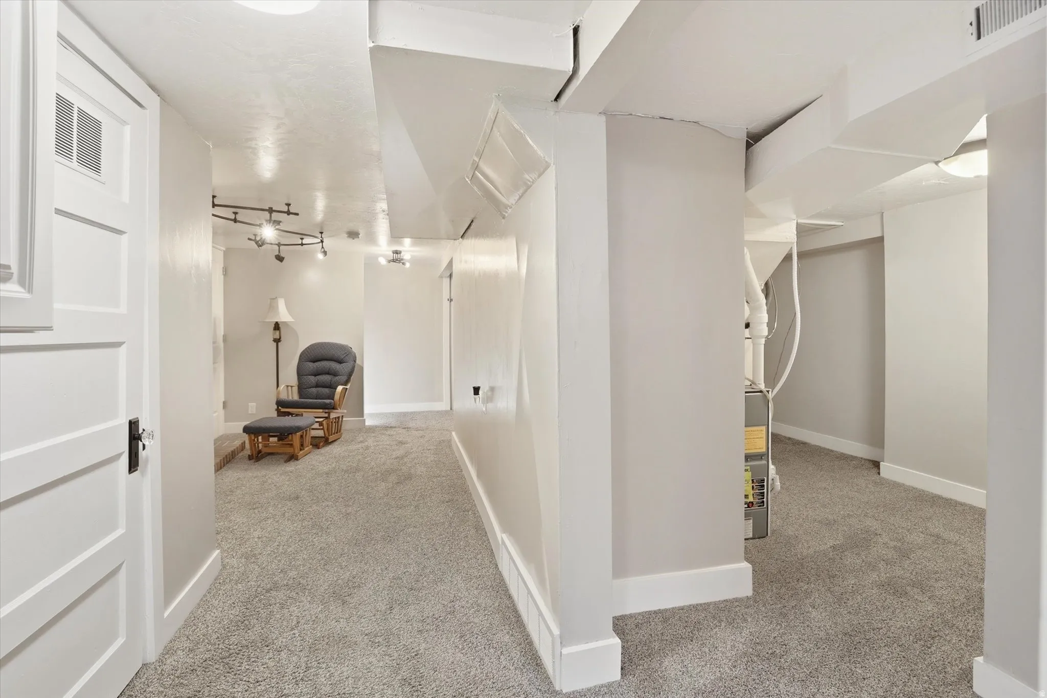 Finished lower level with track lighting, recessed lighting, white baseboards, and light gray walls
