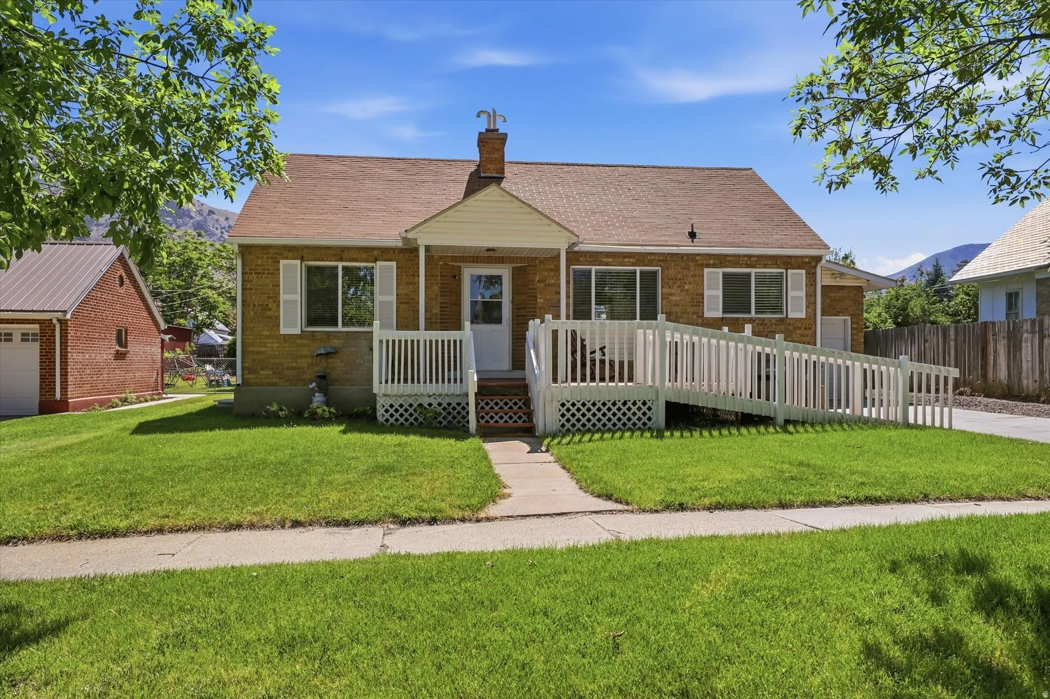 Brick exterior residence featuring a front lawn and paved driveway