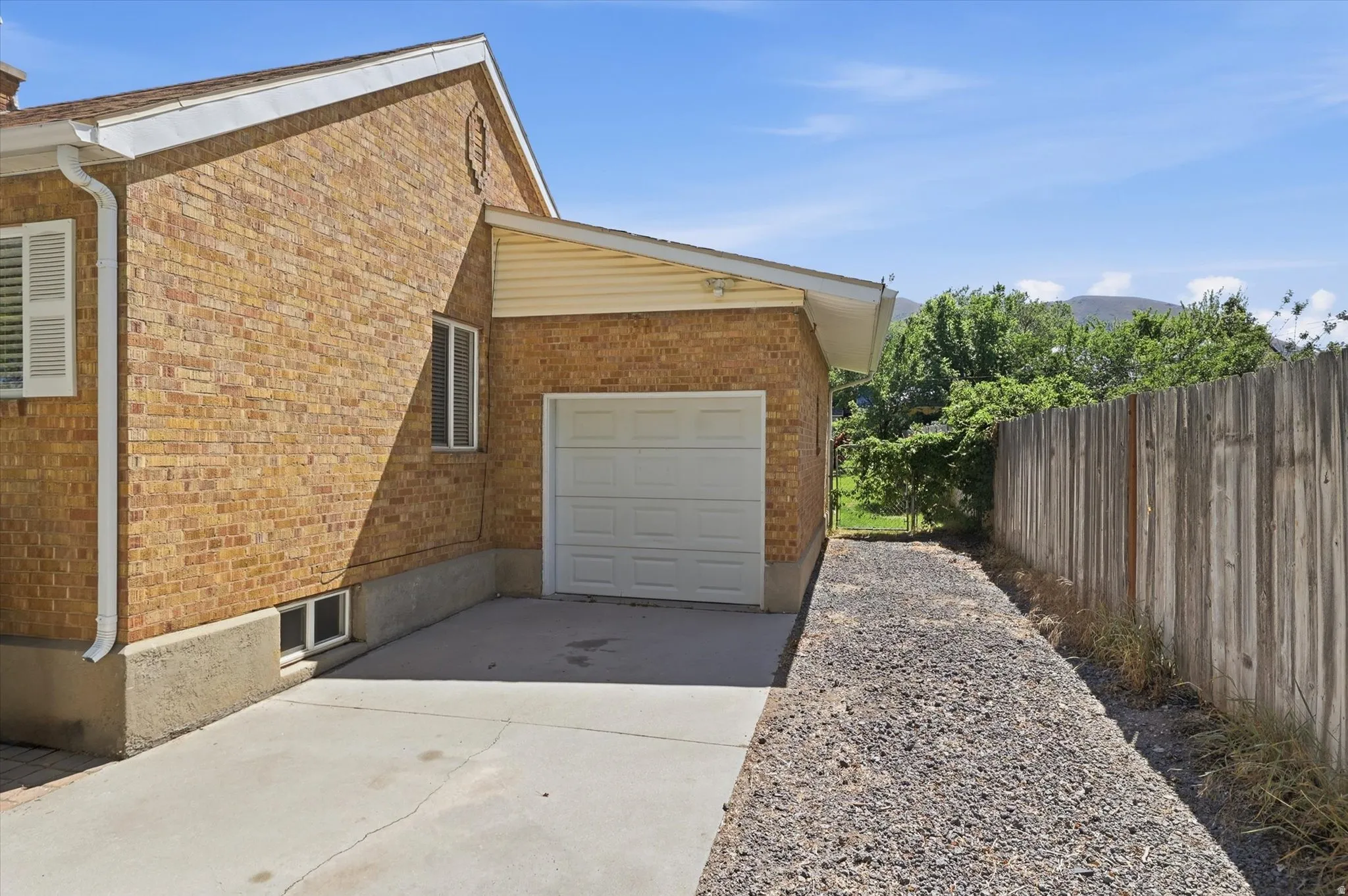 Brick exterior with an attached single-car garage and concrete driveway
