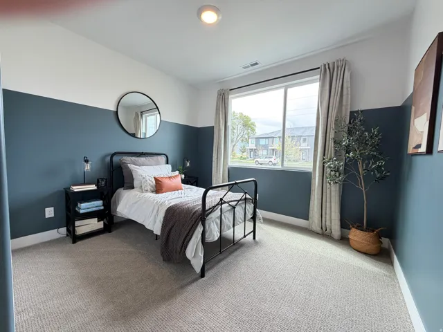 Bedroom featuring a large window, patterned carpeting, two-tone painted walls, and recessed lighting