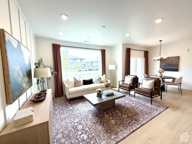 Open-concept living area featuring a prominent picture window, recessed lighting, and light wood-finish flooring