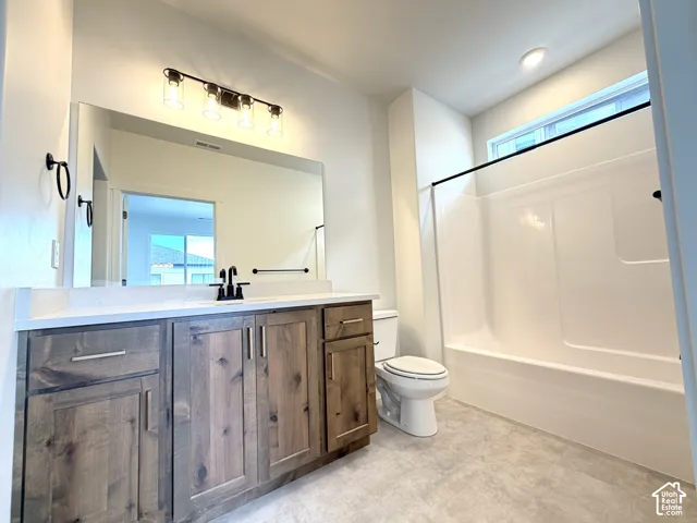 Spacious vanity with wood-finish cabinetry, white countertop, and matte black fixtures