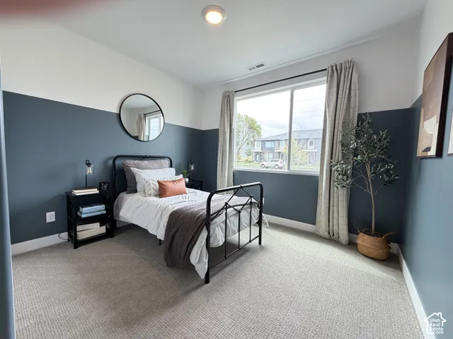 Bedroom featuring a large window, patterned carpeting, two-tone painted walls, and recessed lighting