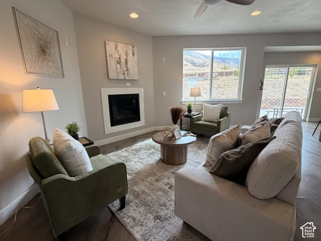 Spacious living area featuring a fireplace with white surround, recessed lighting, and wood-finish flooring