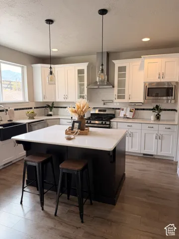 Wood-finish flooring throughout, complemented by a white subway tile backsplash with decorative black trim