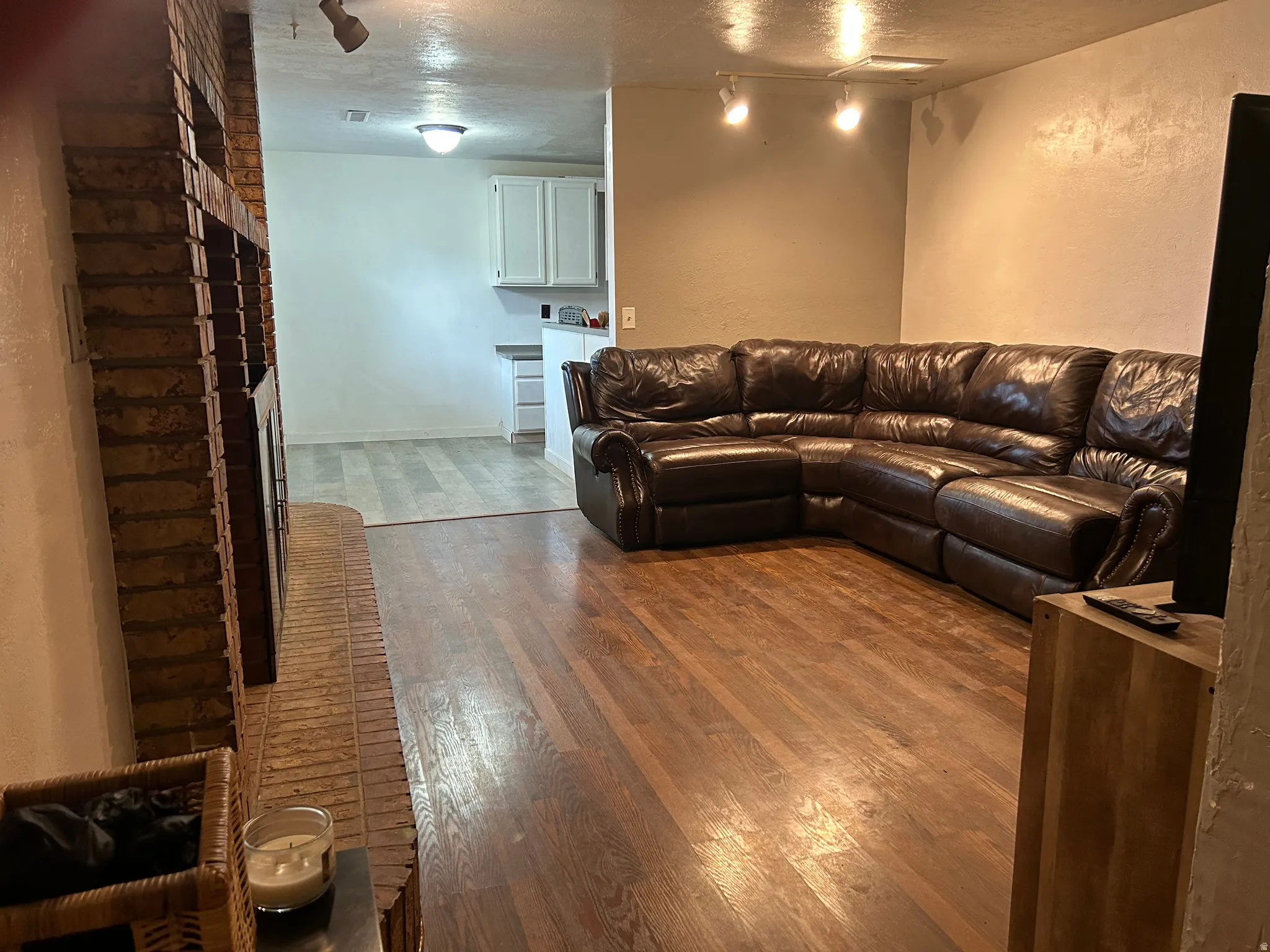 Living area featuring wood-finish flooring and a brick fireplace surround