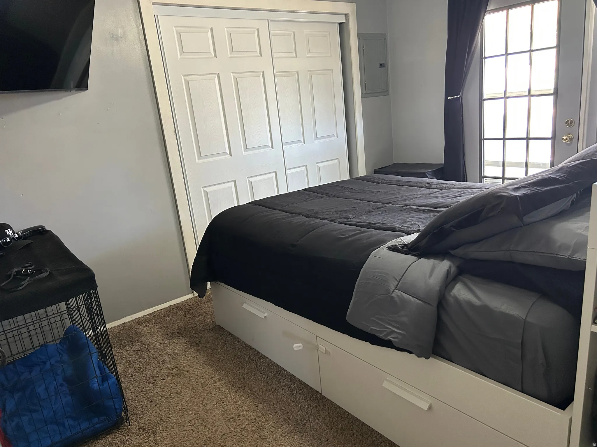 Bedroom featuring a white sliding closet door, light grey wall paint, and a hinged glass-paned door