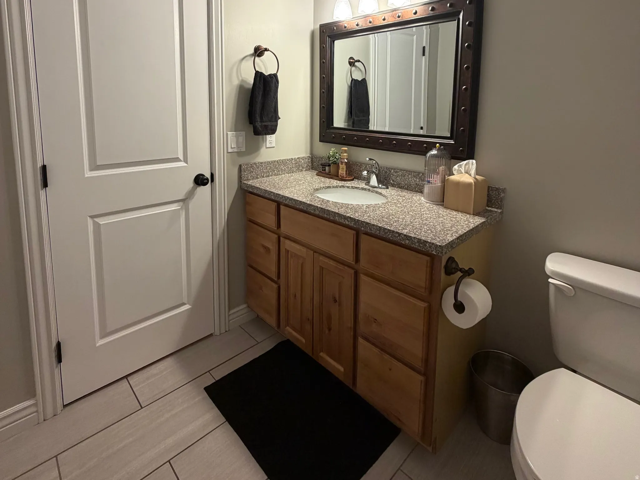 Bathroom vanity featuring a speckled countertop, integrated sink, and wood cabinetry