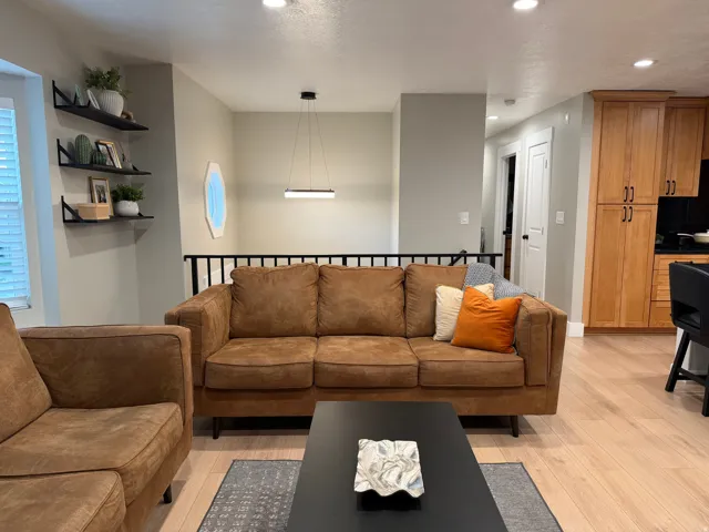 Open concept living space featuring light wood-finish flooring, a contemporary linear pendant light fixture, and recessed lighting