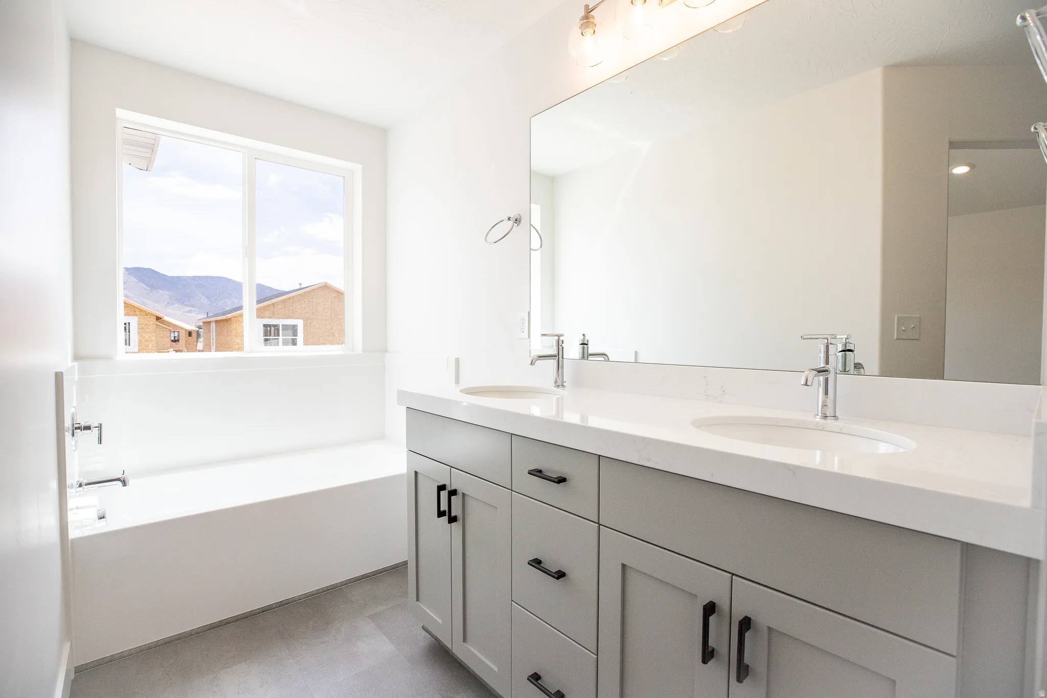 Great primary bath with dual sinks, painted wood cabinets, quartz slab countertops, soaker tub and shower.