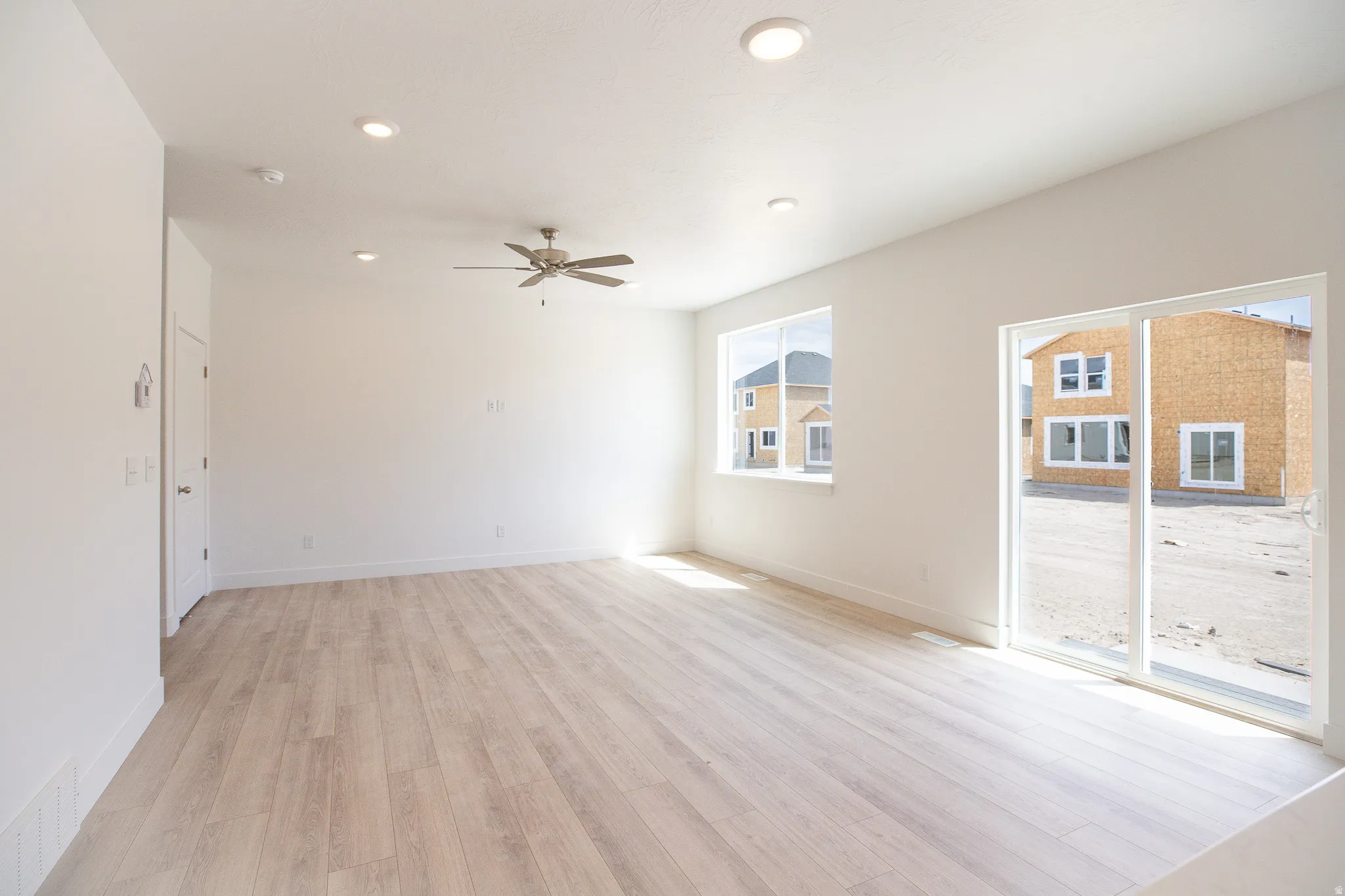Large family and dining area with 9' ceiling and ceiling fan.