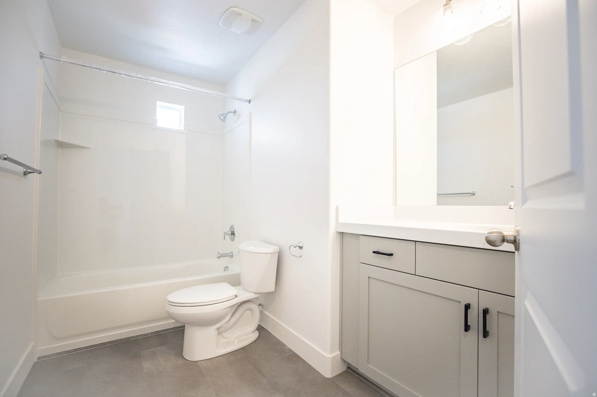 Full secondary bath with painted wood cabinets and quartz slab countertops.