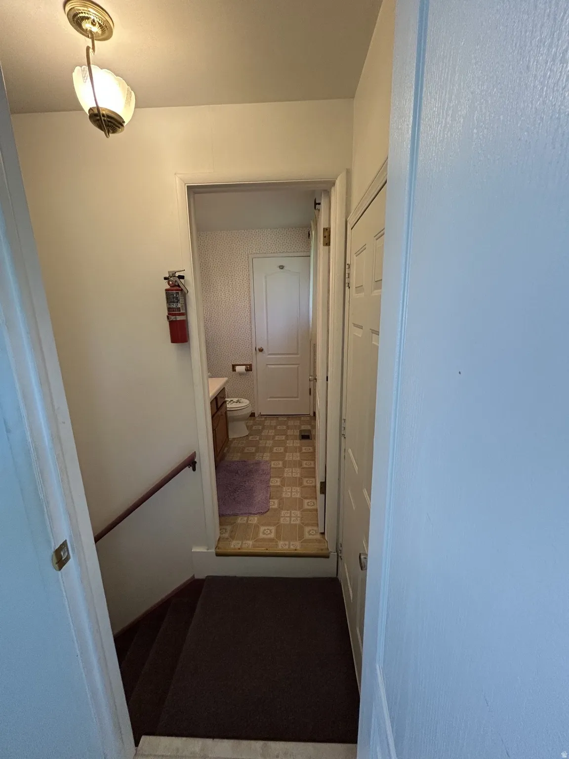 Door from Kitchen to stairs, 1/2 bath & the door to the back yard to the right.
