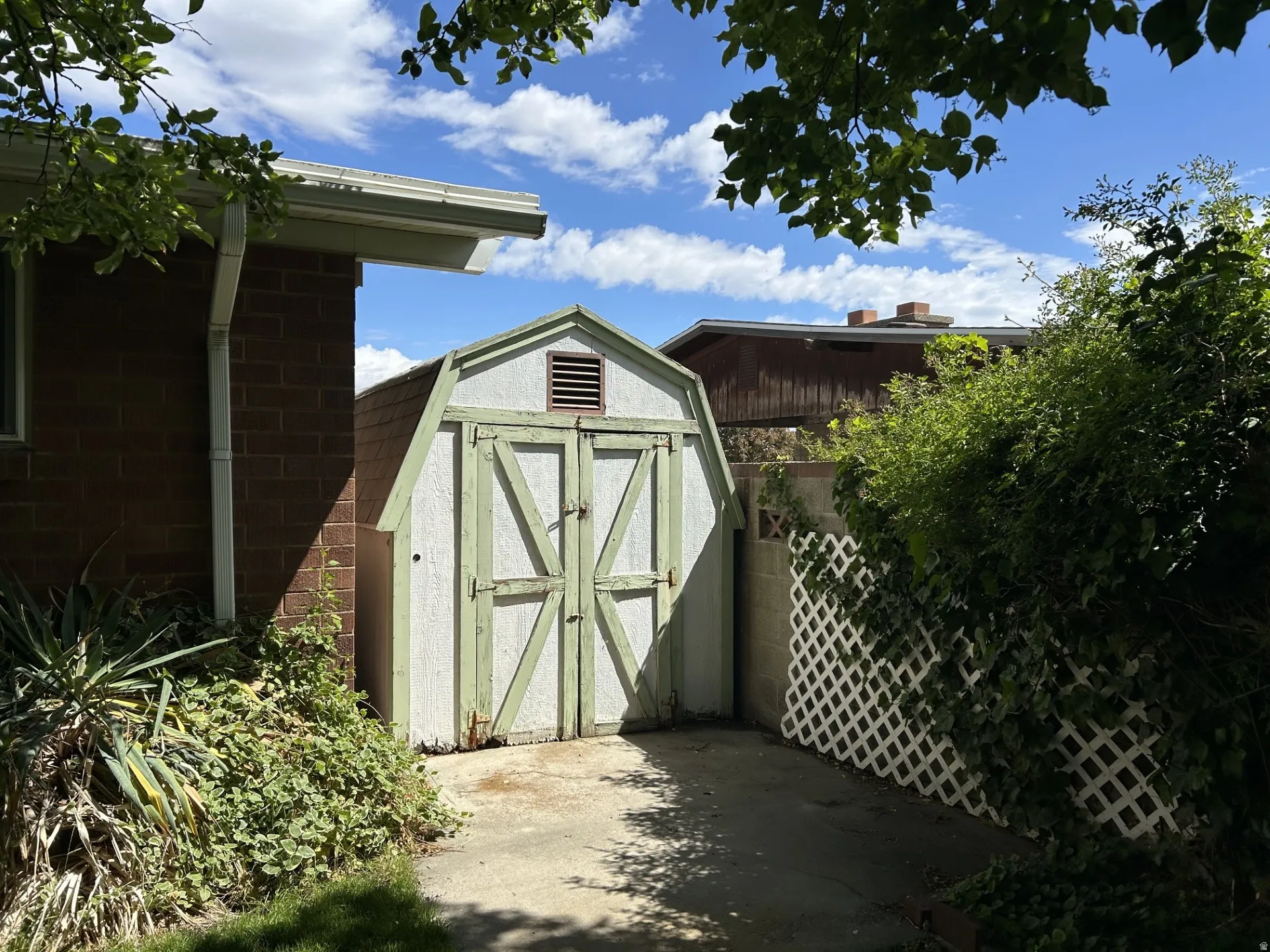 Detached storage shed with barn-style doors and attic vent