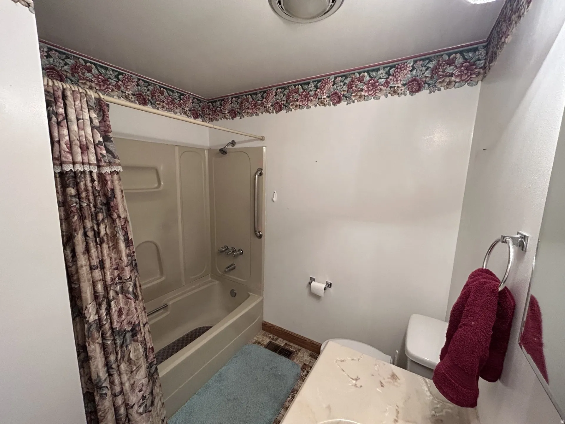 Main Full Bath/Shower featuring a tub/shower combination with grab bar, white toilet, and a vanity with a light-colored countertop.