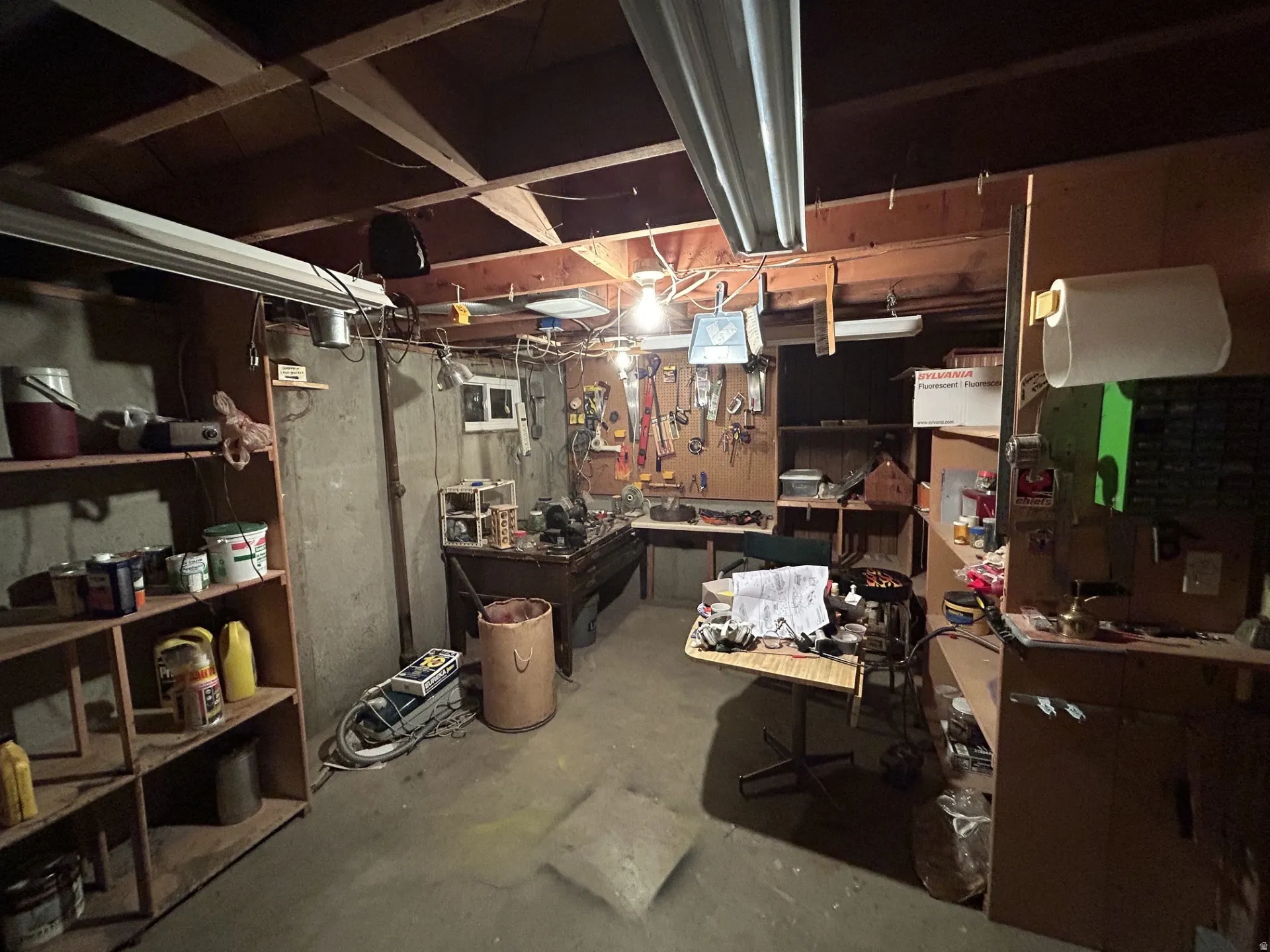 Unfinished basement with extra shelfing for storage & projects.