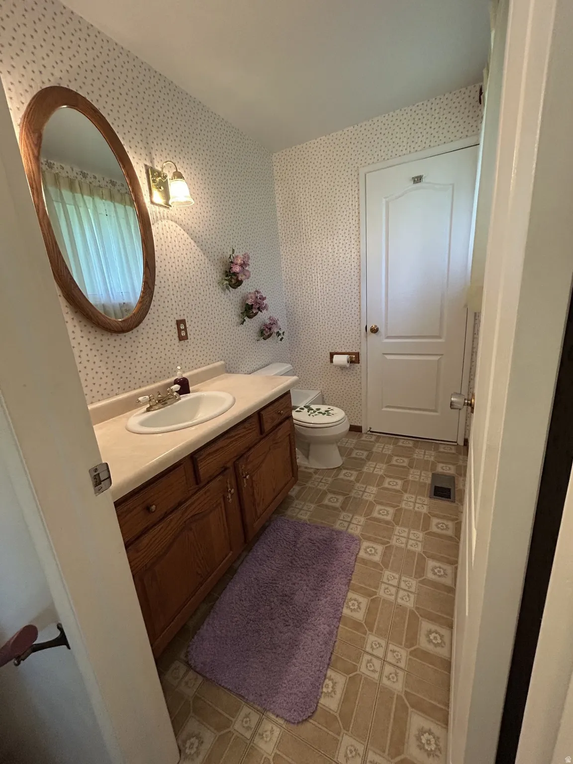 Half Bathroom vanity featuring a built-in sink, wood-finish cabinetry, and a countertop