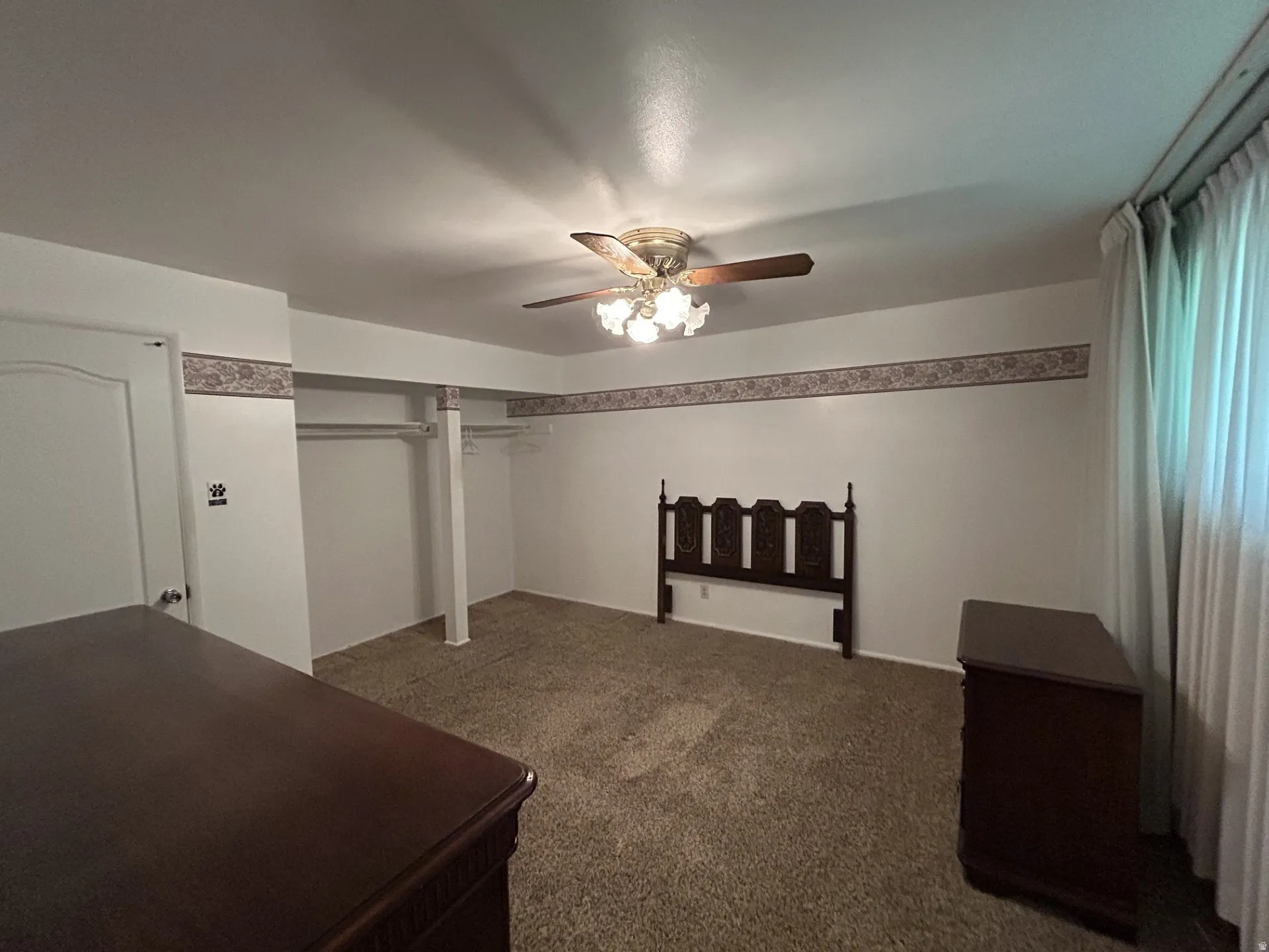 Main Bedroom with carpet,  a ceiling fan light fixture, white walls, and a decorative border. Seller may include this furniture if the buyer is interested.