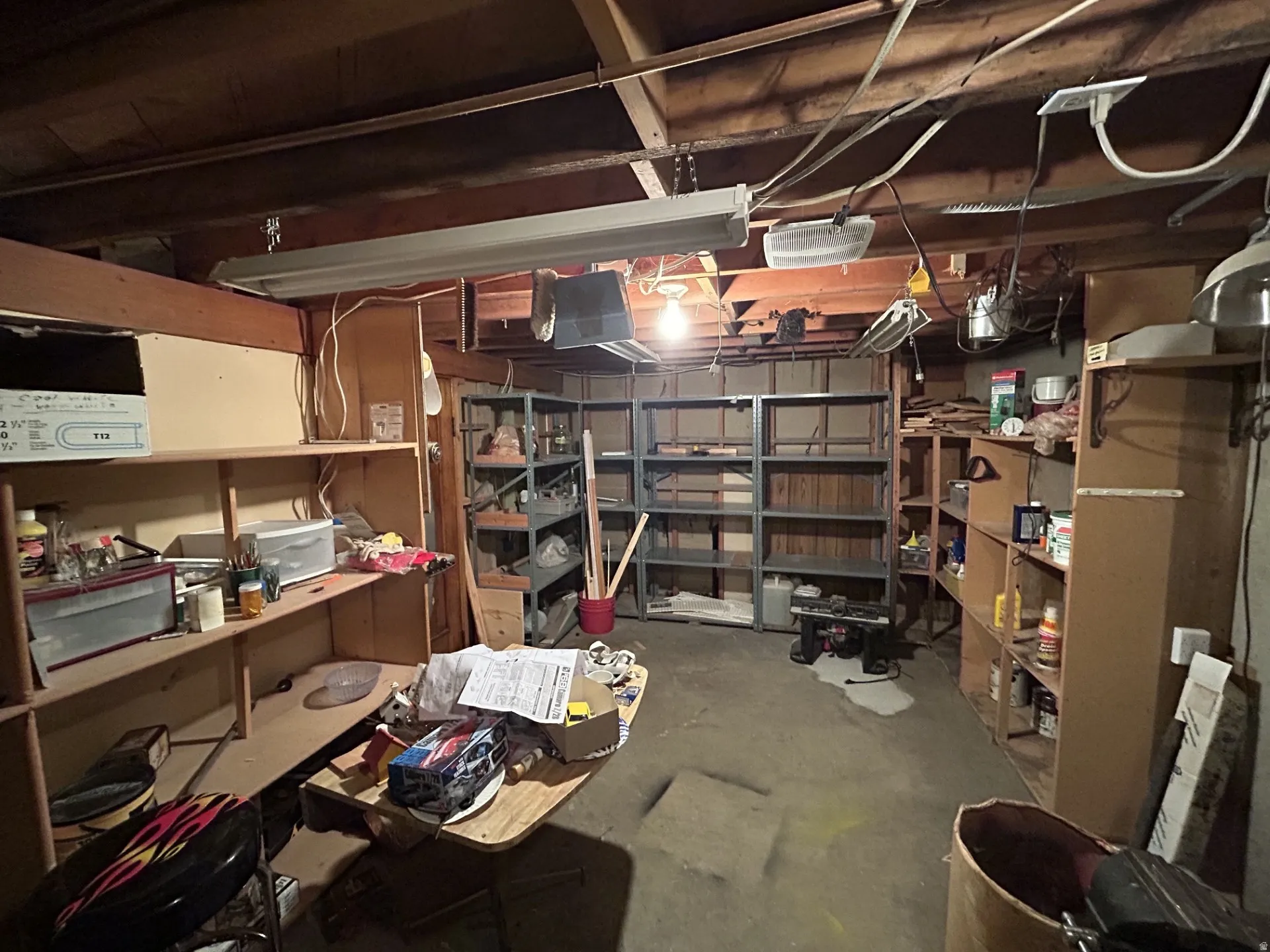 Unfinished basement with extra shelfing for storage & projects.