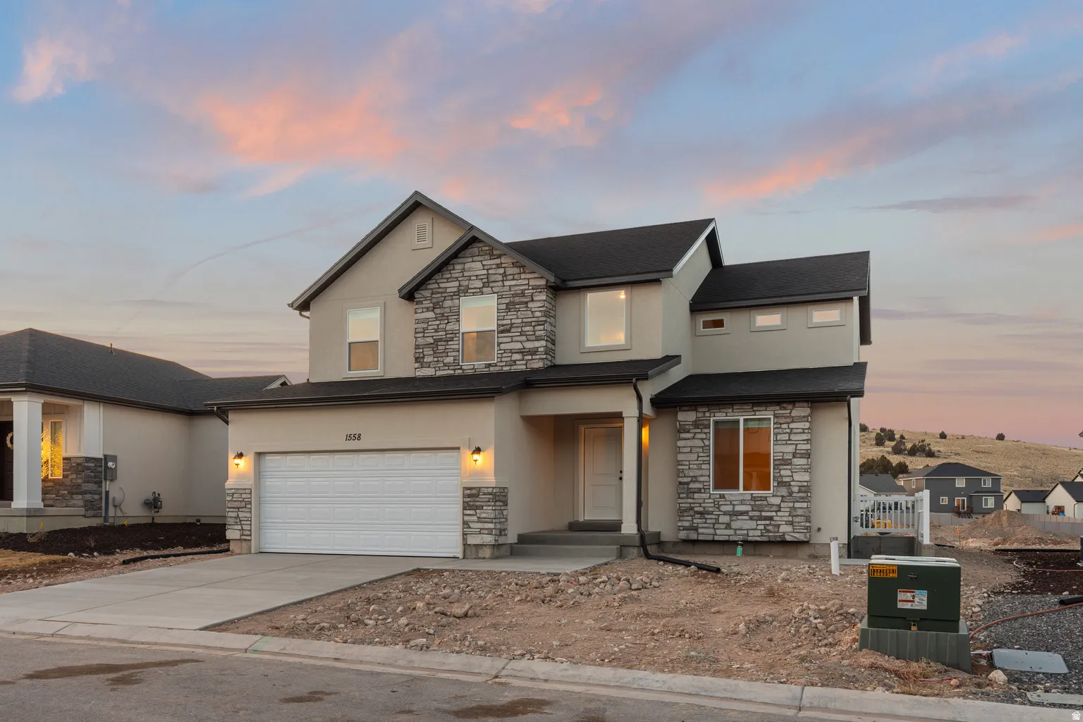 Contemporary two-story residence featuring a stucco and stone veneer facade