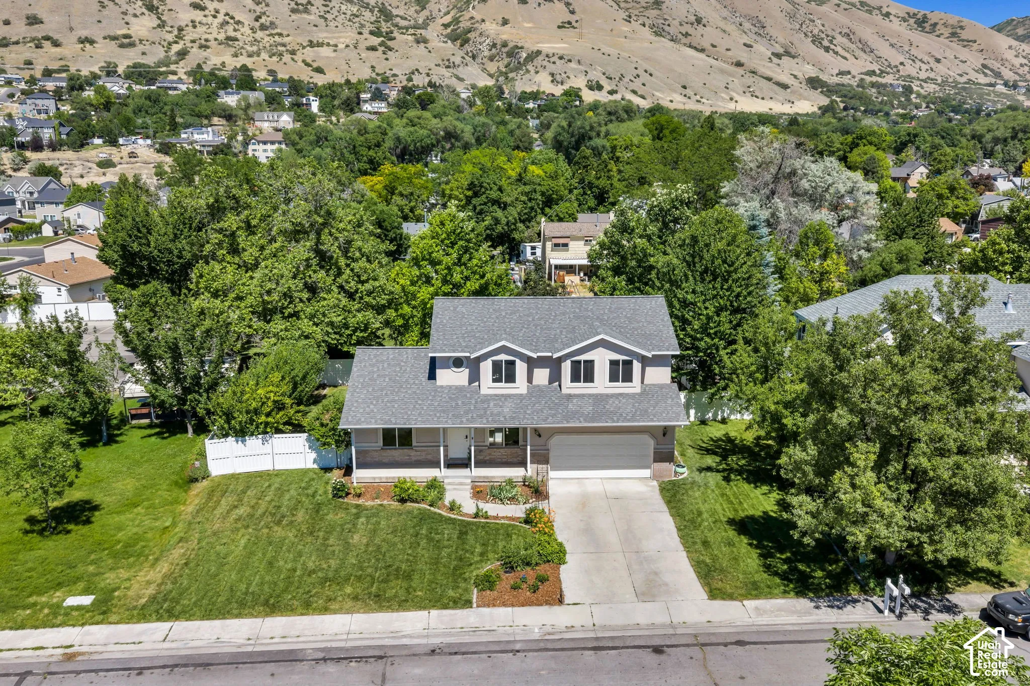 Two-story residence featuring a gray shingled roof and light-colored siding